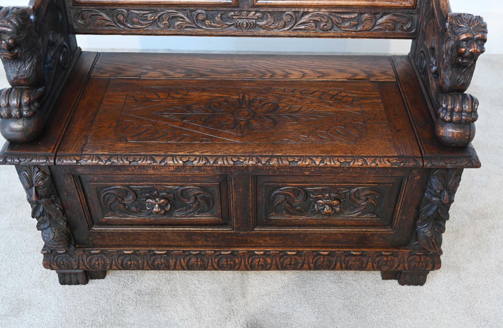 You are viewing a gorgeous carved oak settle or bench
Hopefully the photos illustrate the details to the carving
The back panels show intricate tavern scenes in relief
To the top are two little busts and of course the creature arms are very