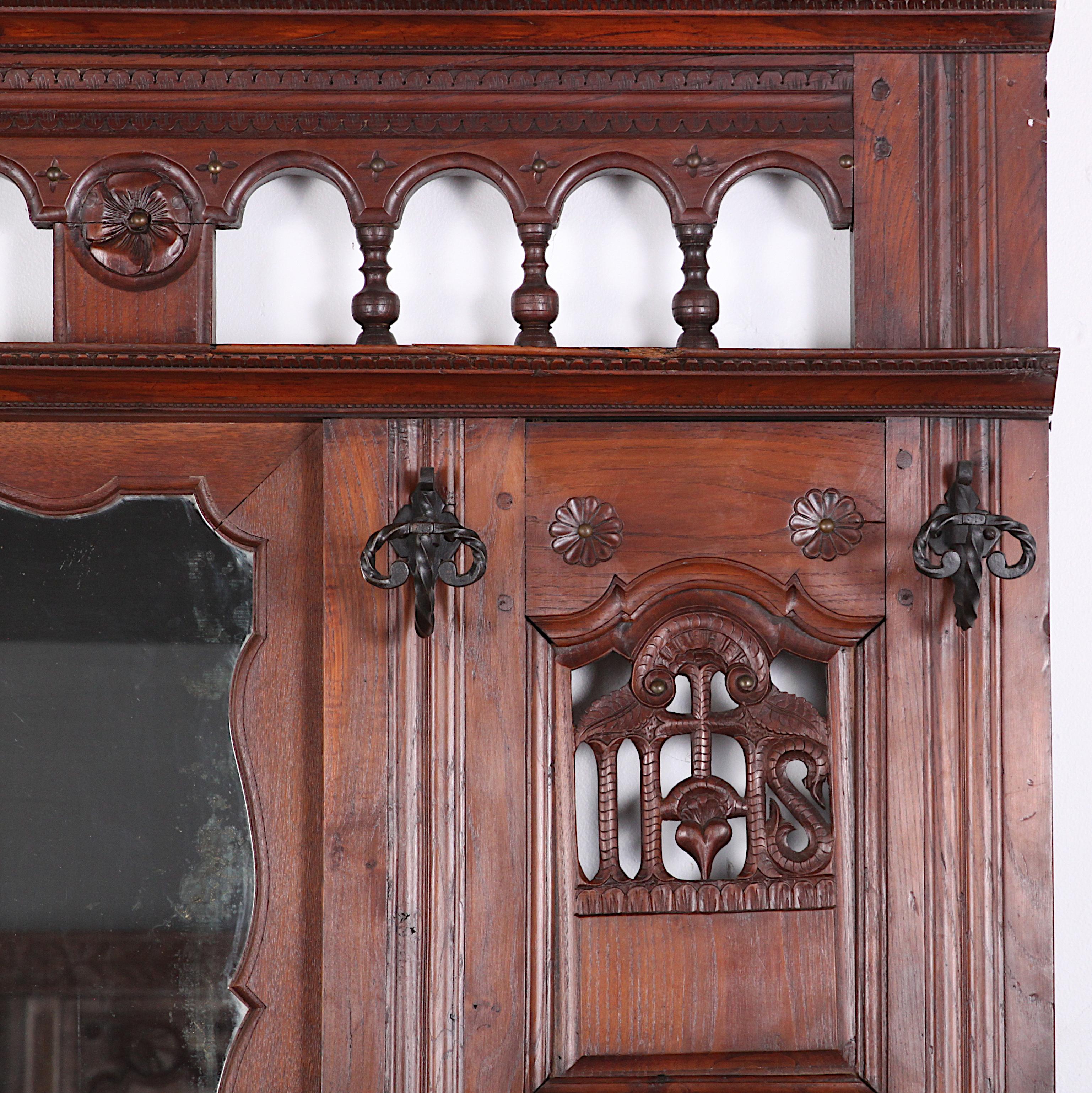 A 19th century French oak and elm hallstand or coat rack with shaped panels and pierce-carved details, originally the facade of a Breton 'lit close' or enclosed bed. C. 1880.