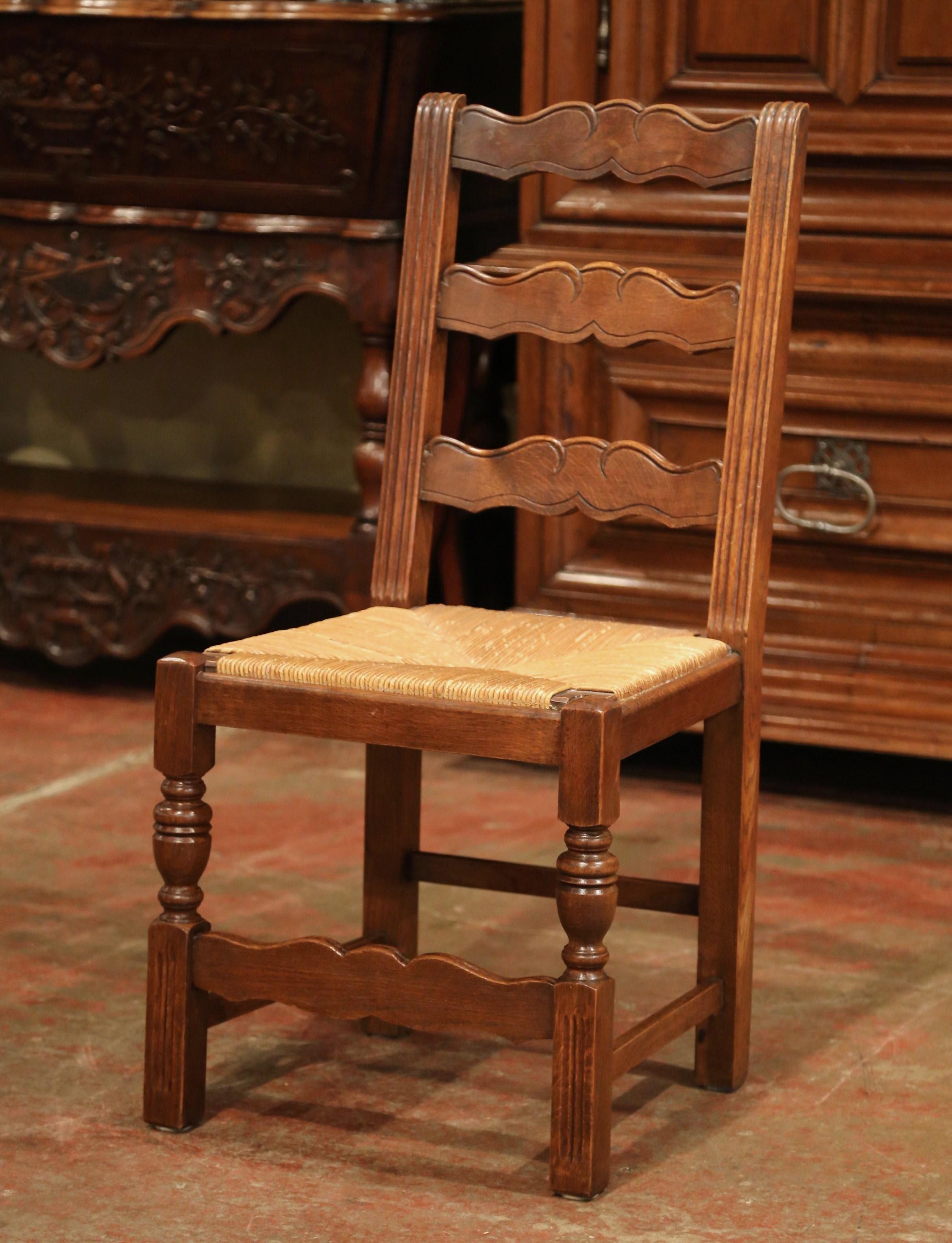 This elegant set of country chairs was crafted in France, circa 1980. Carved from solid oak, each chair has three ladders across the pitched back which give each chair great support and comfort. The seat has woven rush surface over four carved and