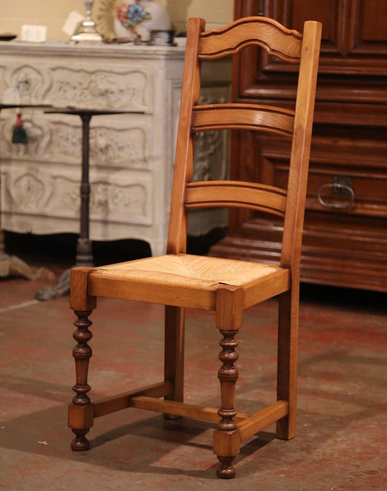 These six elegant country chairs were crafted in France, circa 1990. Carved from solid oak, each chair stands on carved turned legs embellished with a bottom stretcher. Each chair has a tall pitched back with three ladders across for great support