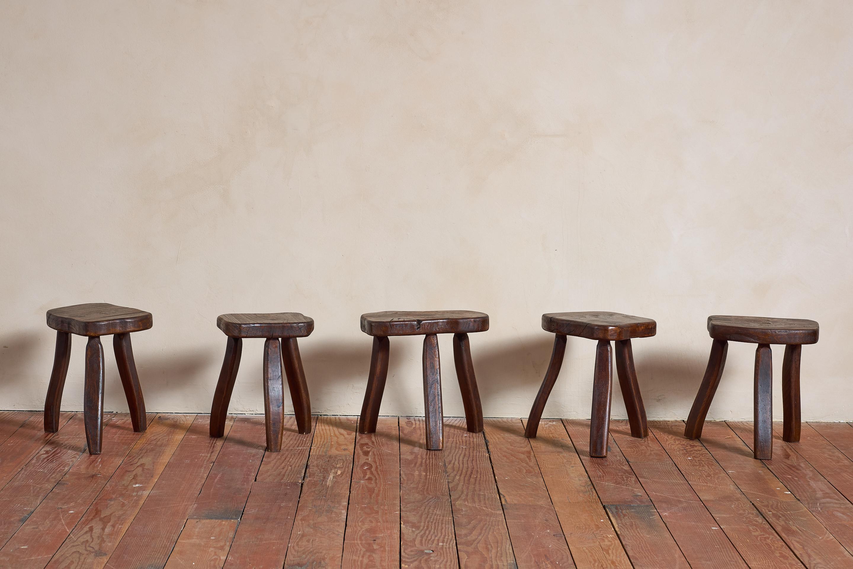 Handgeschnitzter Hocker aus massiver Eiche, Frankreich, 1950er Jahre.

Jedes Stück hat einen unregelmäßig geformten Sitz mit einem dreibeinigen Fuß.

Reichlich gebeizte Patina mit sichtbarer Maserung und organischer Form.

Die Größen variieren