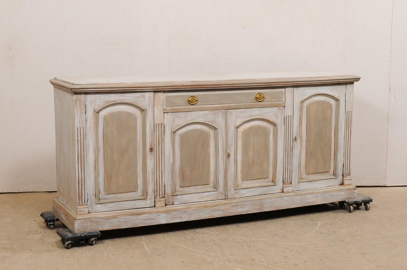 A French carved and painted wood buffet console cabinet from the turn of the 19th and 20th century. This antique sideboard from France, approximately 7 feet in length, features a rectangular-shaped top with molded edge, above a case which houses a