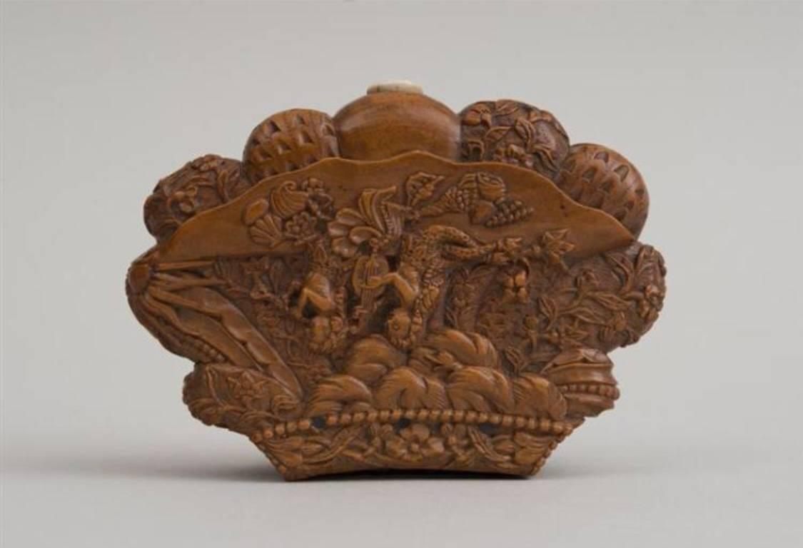 The elaborately carved snuff box with a scene of two mermaids on the cover and deeply carved shell on the reverse.