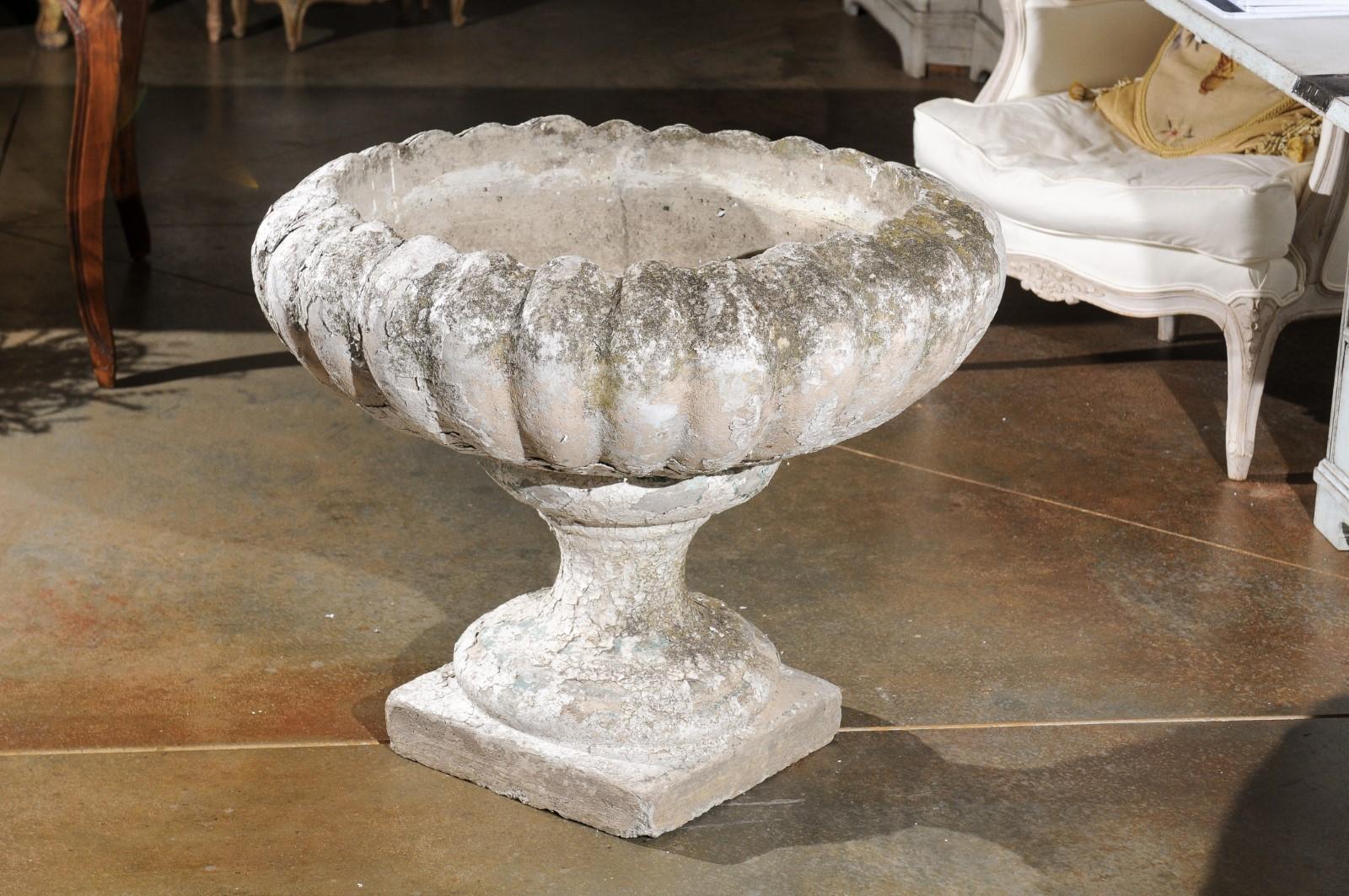 A French large carved stone garden urn from the 19th century, with nicely weathered appearance and gadroon motifs. Born in France during the 19th century, this exquisite garden urn features a circular body adorned with gadroon motifs, presenting a