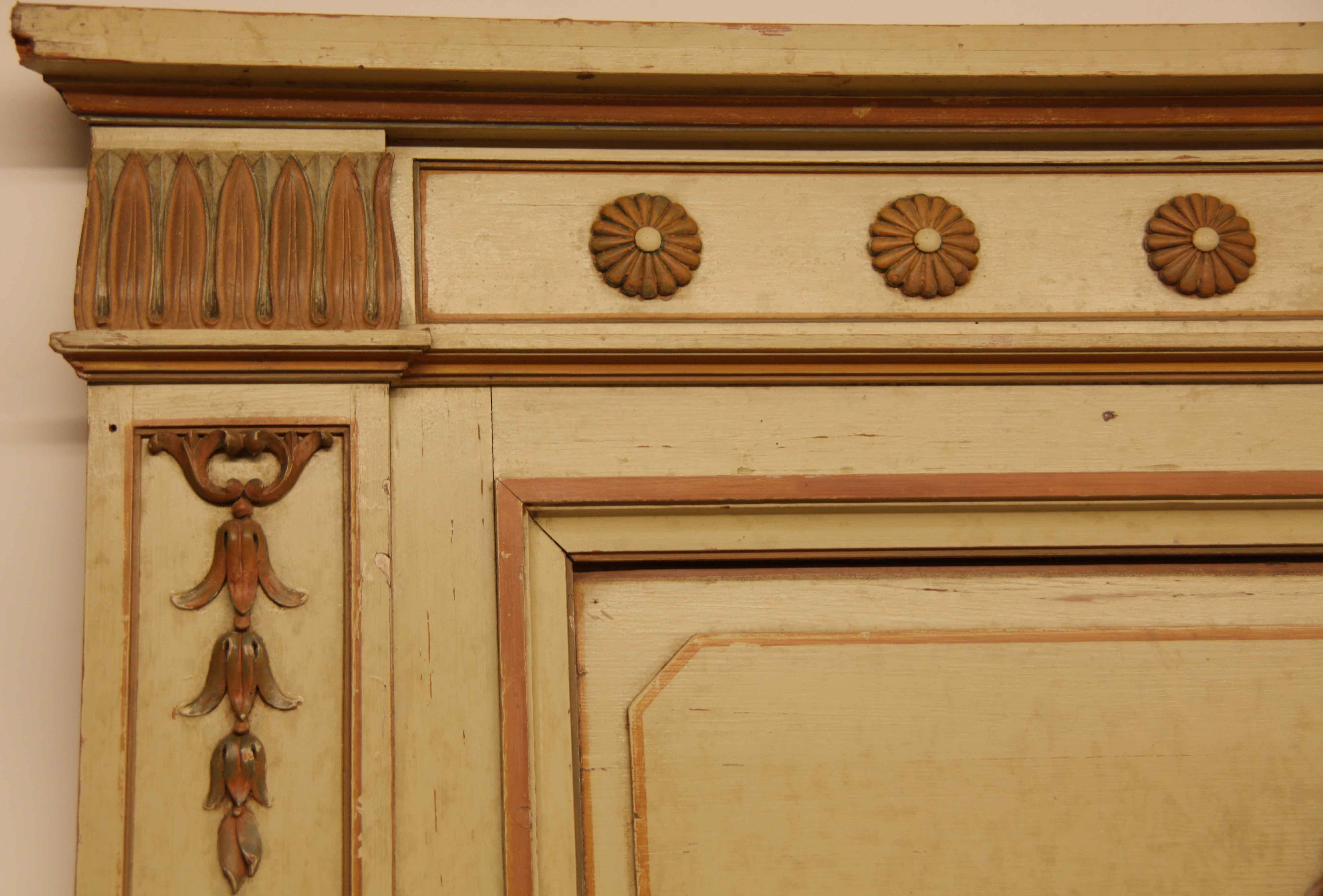 French Carved Trumeau,  the flat and molded cornice is above a frieze with stylized foliage at each end and a row of scallop shaped rosettes in the center.  Below this is an inset panel with carved urn with trailing bell flower in high relief. 
The