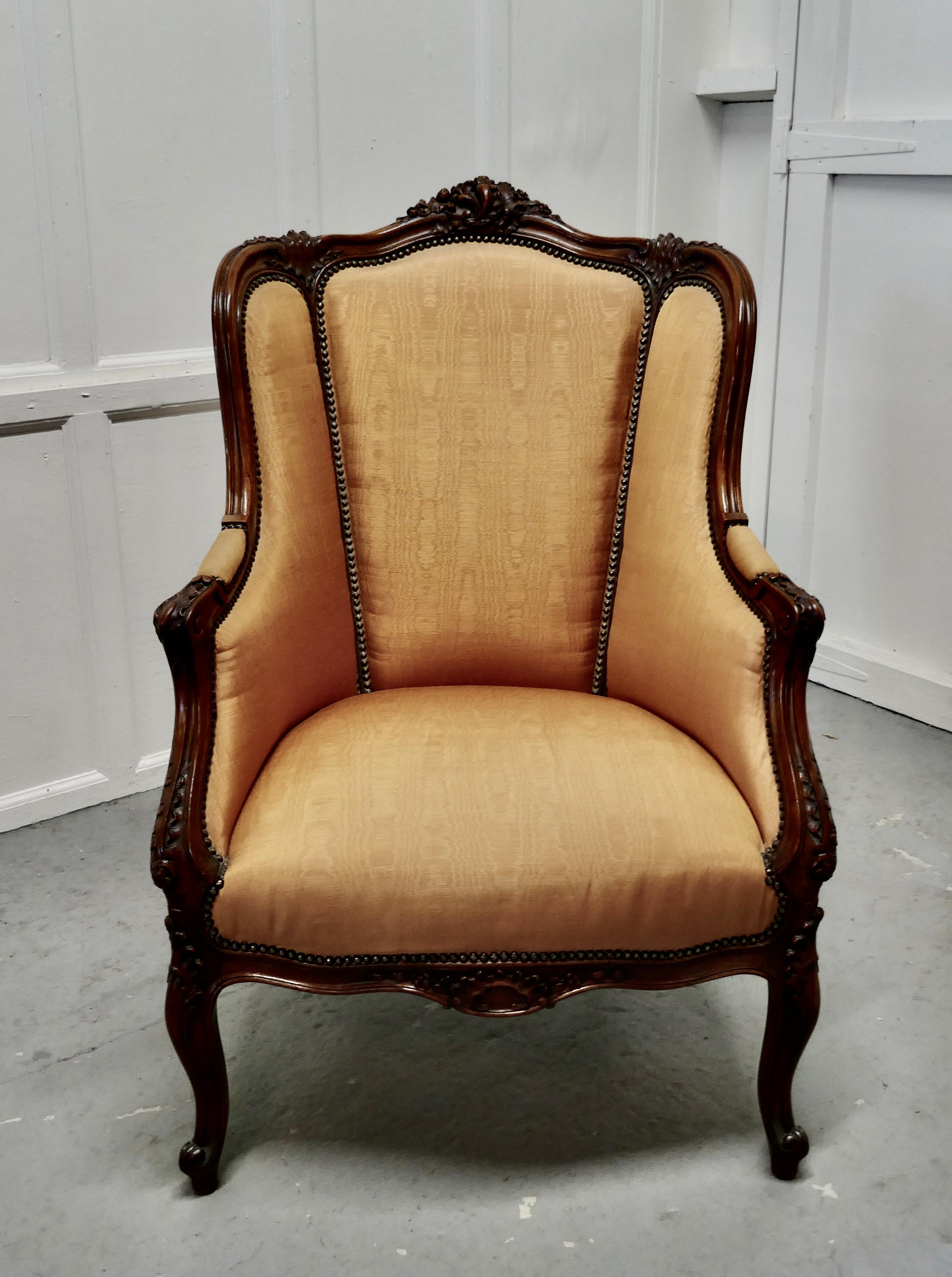 French carved walnut and salon chair, upholstered in silk

This beautiful carved walnut chair, dates from around 1950, it is upholstered in Water Silk which is a glorious Marigold colour with brass stud work. 
The chair is beautifully shaped, the