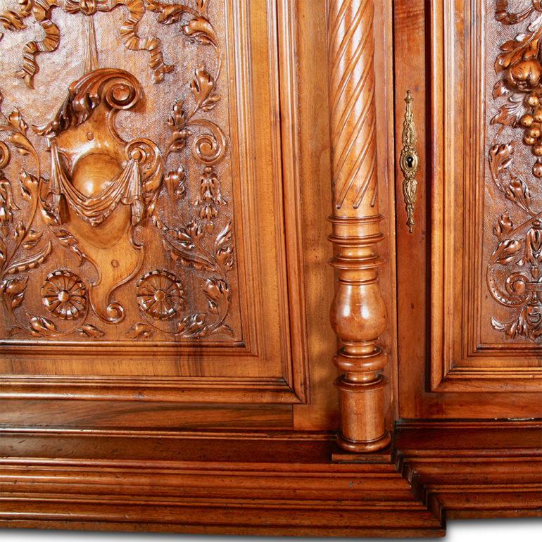 An exceptional, highly-carved, French walnut Henri II or Renaissance revival buffet hutch, the six walnut panelled doors profusely carved with flowers, fruit, faces, etc. The upper cupboard is raised on turned walnut columns which are further carved