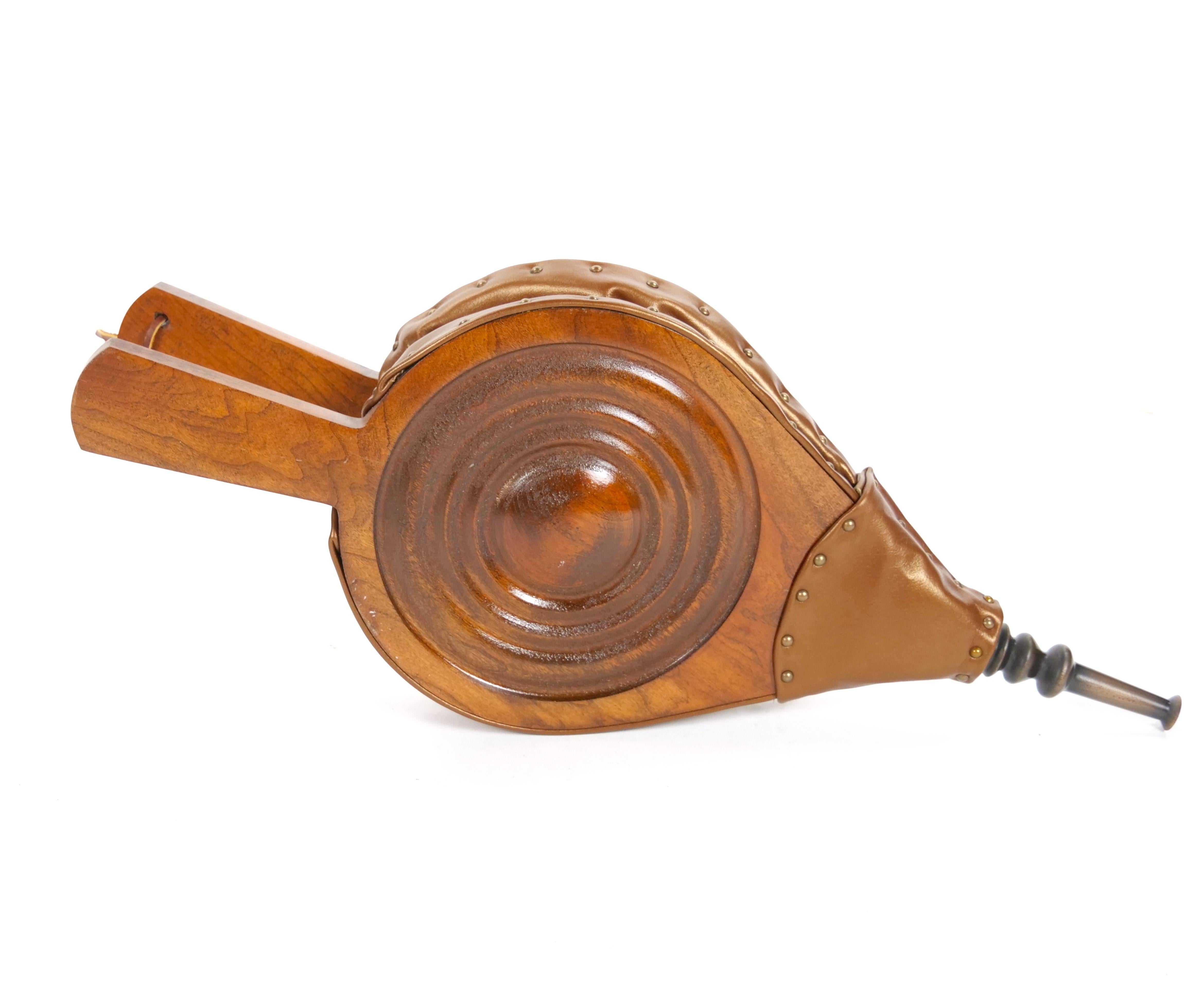 Eleganza per il tuo camino con questo elegante e funzionale soffietto fatto a mano, realizzato in Europa alla fine del XX secolo. Questo squisito pezzo combina legno, ottone e pelle di qualità, offrendo bellezza e utilità. Il soffietto presenta una