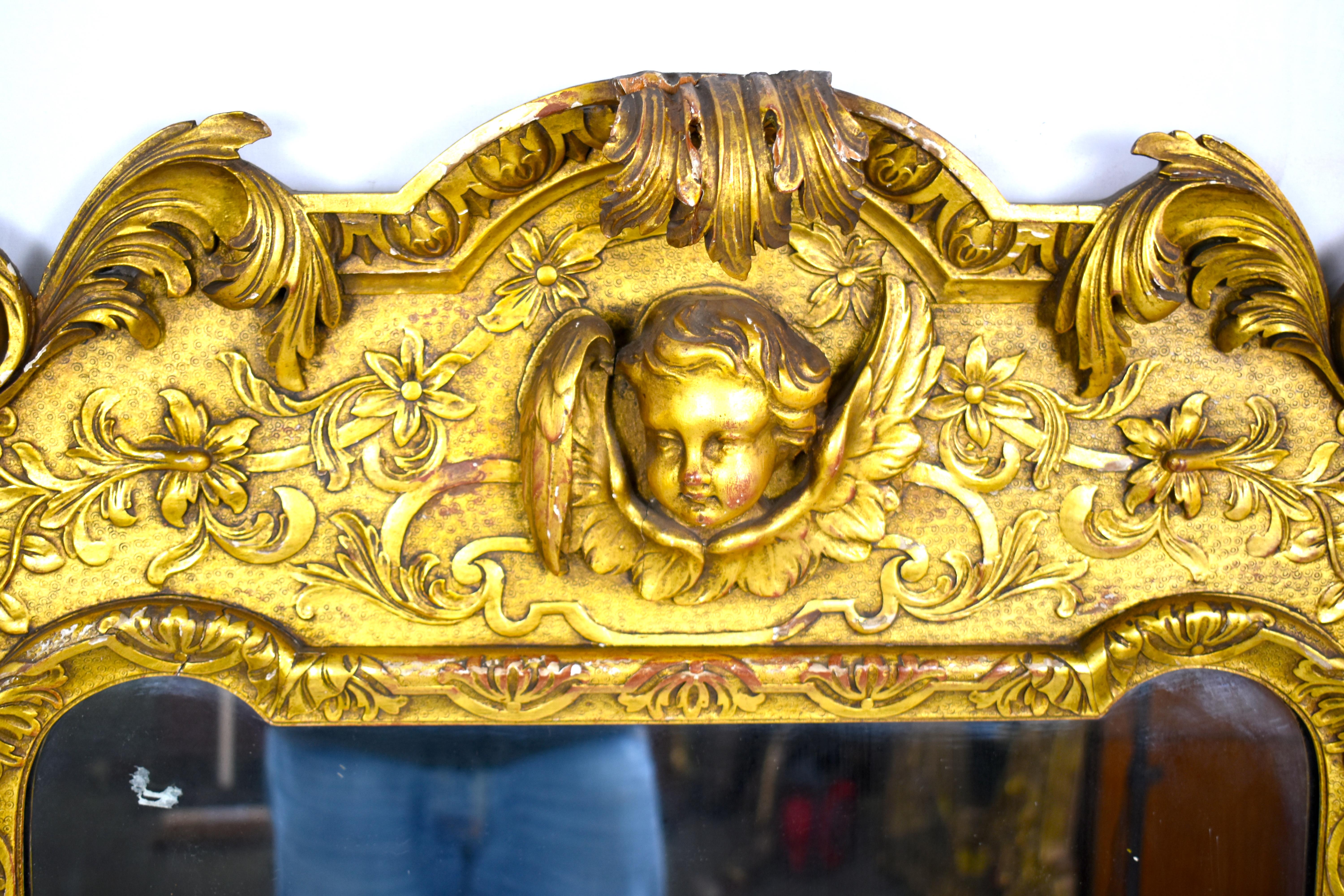A French carved wood and gilt cherub acanthus wall mirror with a cherub head, encapsulated by fine carved floral. Either side sits the head of an eagle.