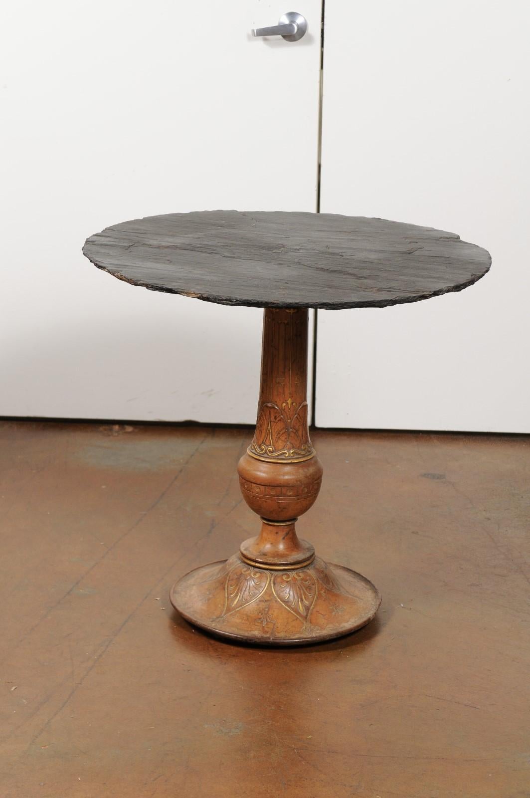 A French carved wood parcel-gilt pedestal side table from the 19th century, with round slate top. This French 19th century table features a circular slate top, sitting above an exquisite turned and carved pedestal base with parcel-gilt accents.