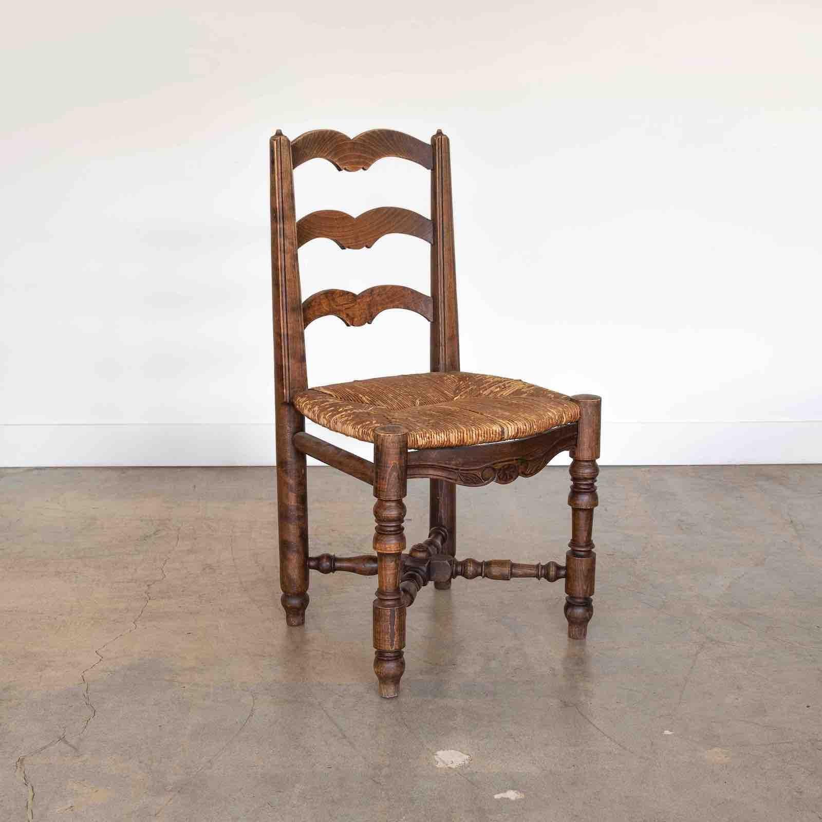 Magnifique chaise en bois sculpté, France, années 1940. Pieds en bois sculpté et cadre en bois avec des détails en forme de volutes. Le siège d'origine en jonc tressé et la finition en bois d'origine présentent une grande ancienneté et patine.