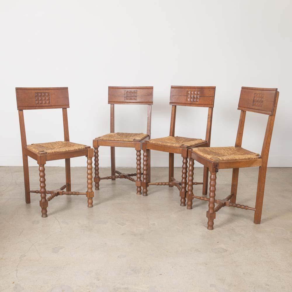 Schöner Satz von vier geschnitzten Holzstühlen aus Frankreich, 1940er Jahre. Aufwändig geschnitzte Holzbeine und Rahmen mit geschnitzten Details. Original Binsen Sitze und Holz-Finish zeigen schöne Alter und Patina. Verkauft als Satz von 4. 
