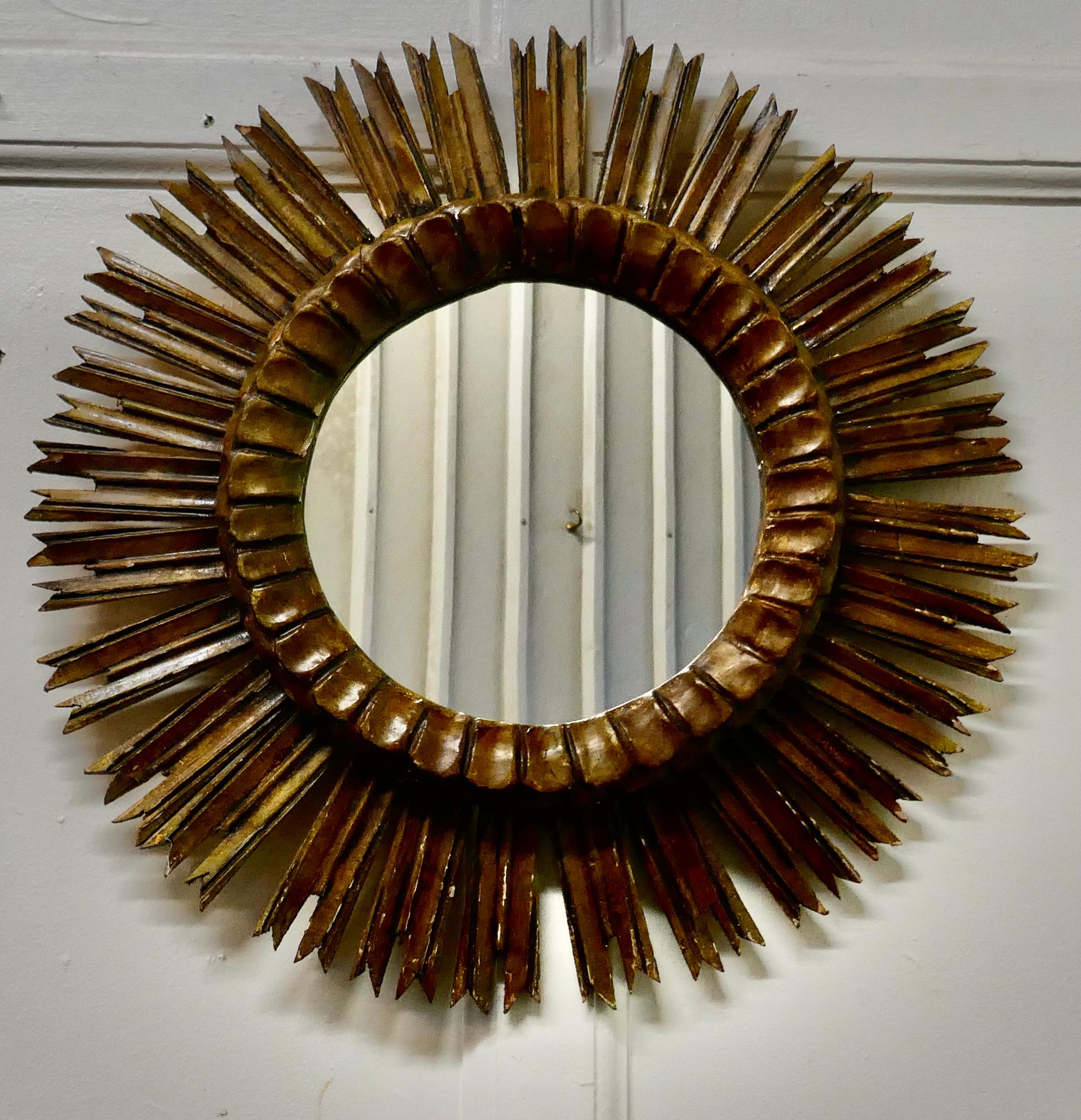 French Carved Wood Art Deco Odeon Style Sunburst Mirror

A Classic from the1920s, a classic and an original statement piece
A Superb piece, the sunburst radiates out from the central mirror, the giltwood rays are all hand carved
This is a