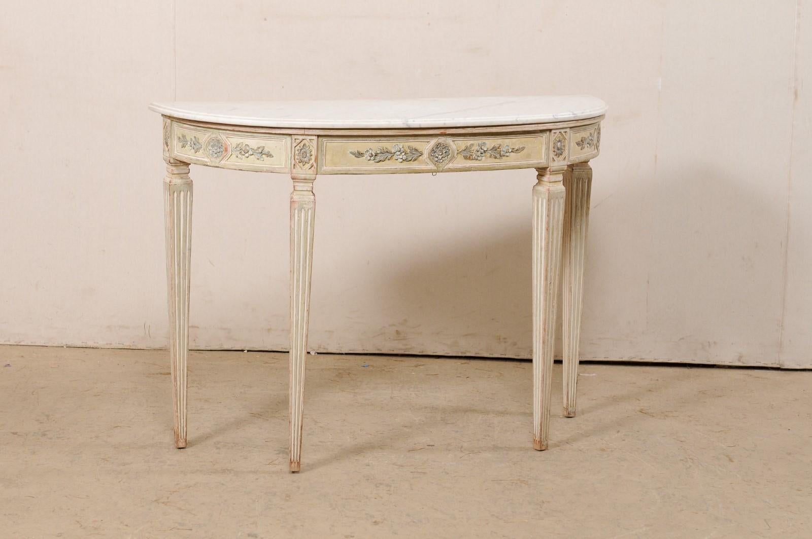 A French marble top carved-wood console table, with its original paint, from the mid 20th century. This vintage table from France has an oblong demilune shape with flat along the backside (so that it can rest comfortably against the wall). The