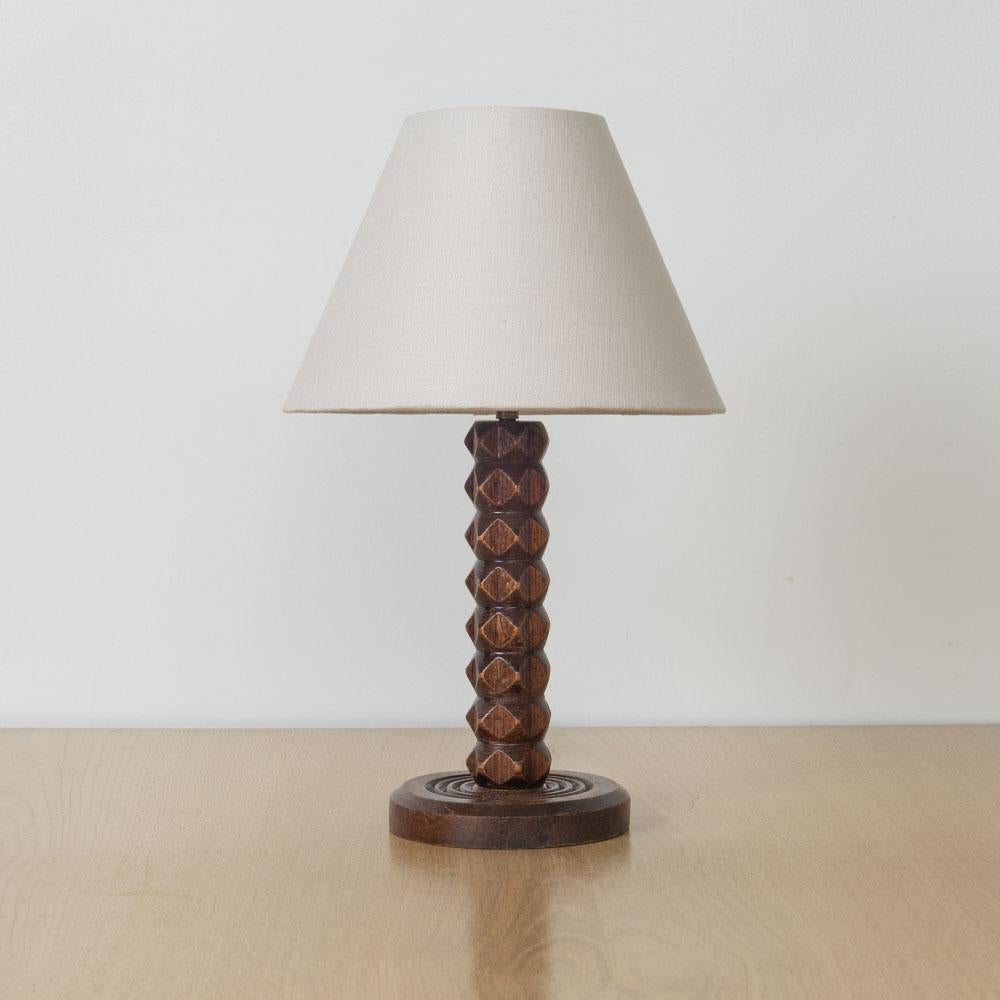 Great carved wood table lamp from France, 1940s by Charles Dudouyt. Beautiful carved chevron design with original dark wood finish. New tapered linen shade and newly re-wired. Original wood finish shows nice age and patina. Takes one E12 base bulb,