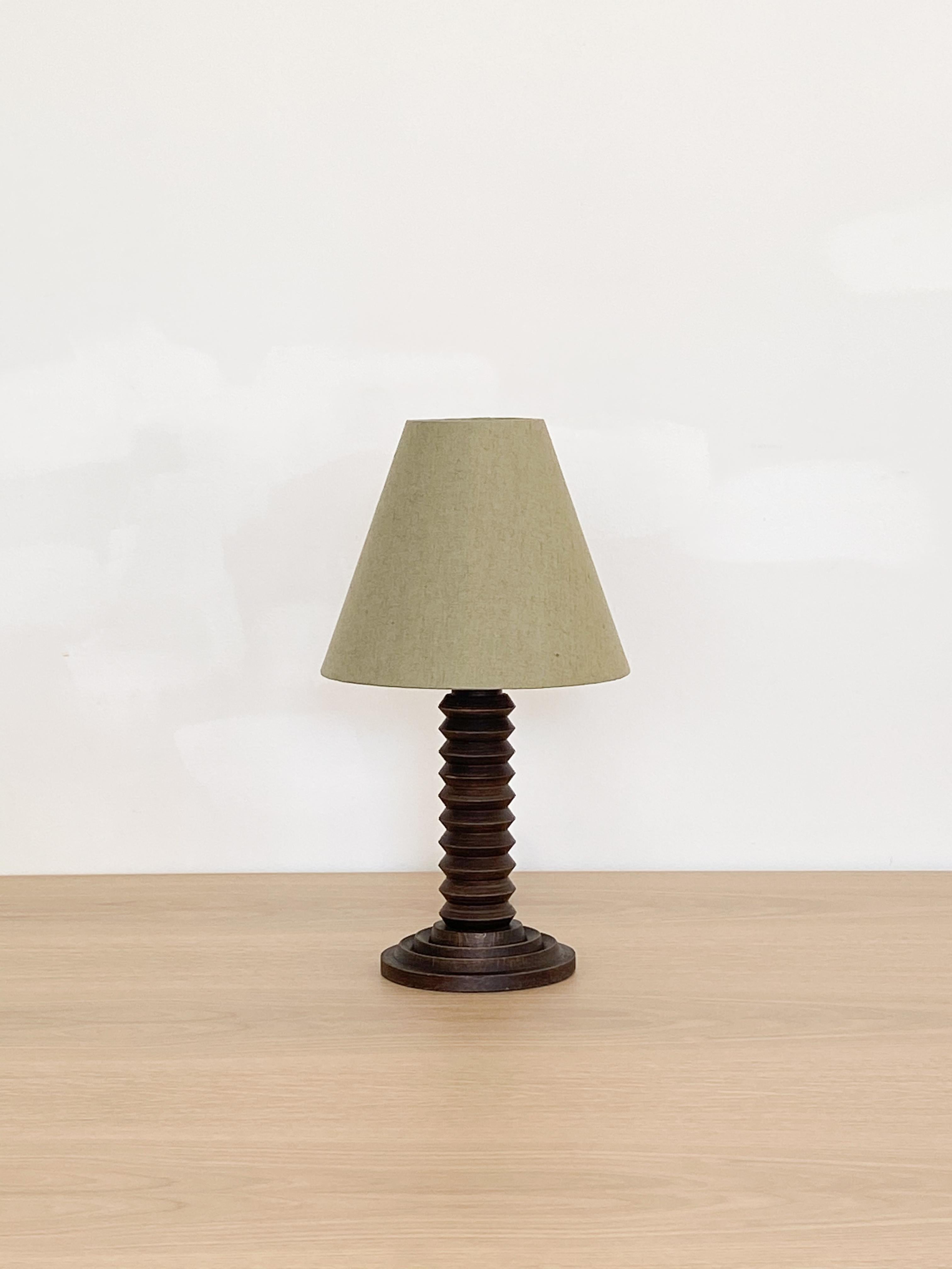 Hand carved wood table lamp from France, 1940s. Carved design with original wood finish. New green linen shade and newly re-wired. 

Measures: Shade diameter 12.25
