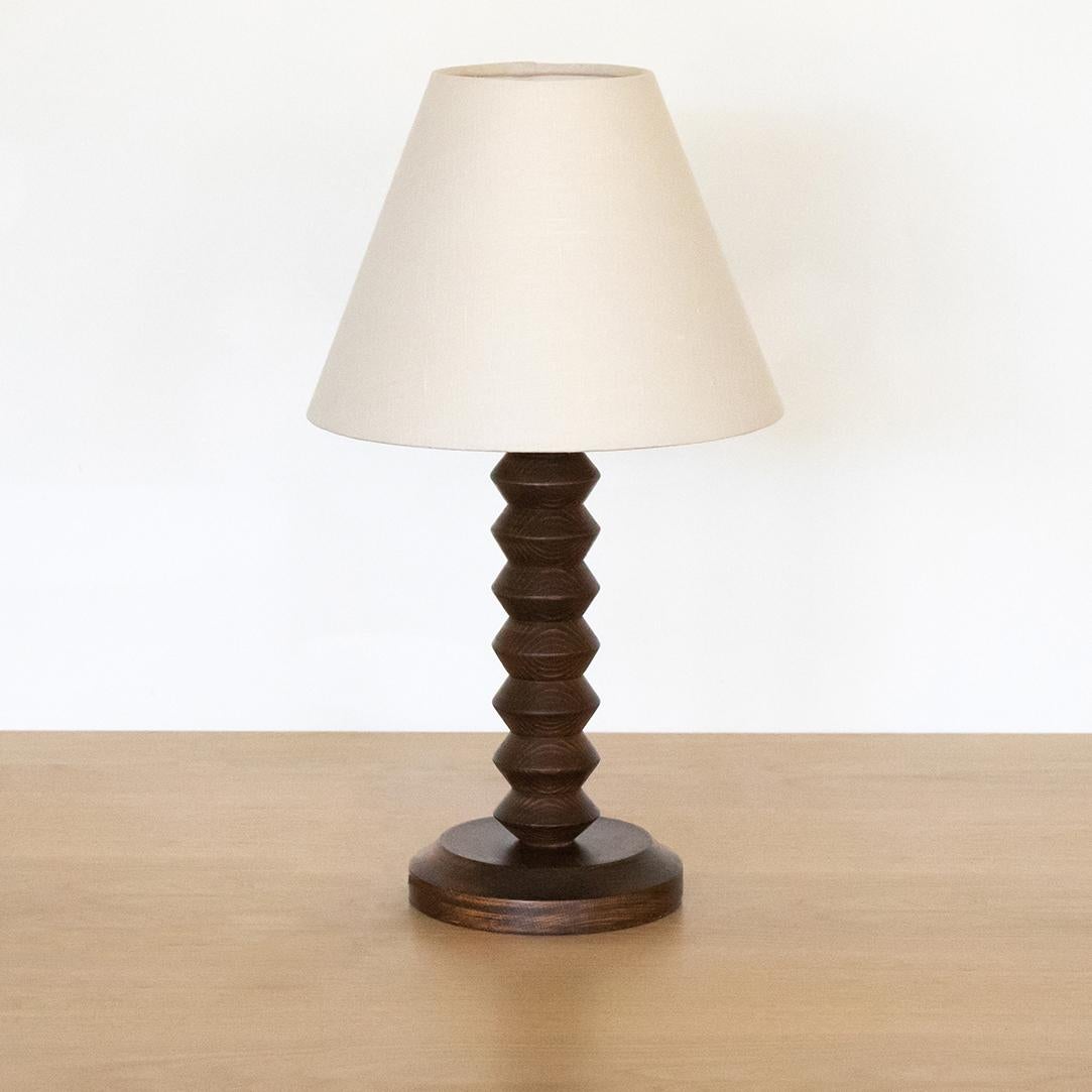 Hand carved wood table lamp from France, 1940's in the style of Charles Dudouyt. Carved design with original wood finish. New oyster linen shade and newly re-wired. 

 