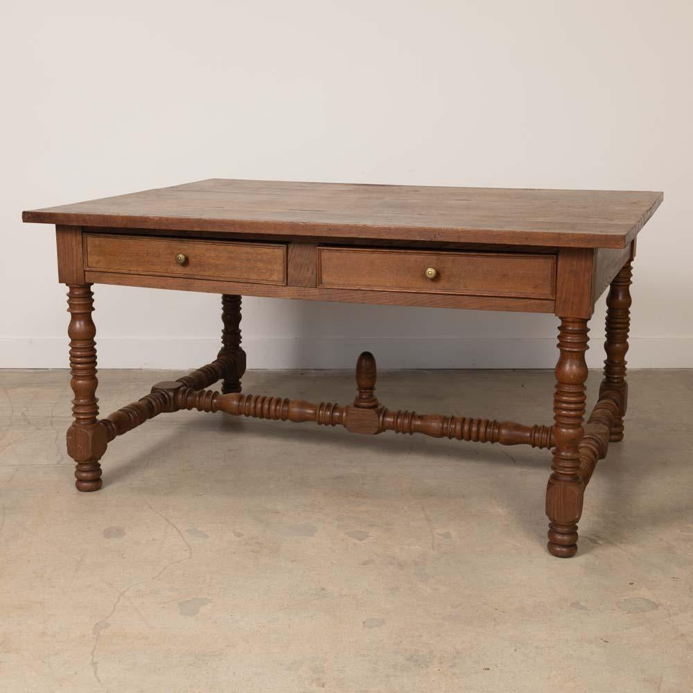 Incredible wood partners desk from France, 1940's. Large rectangular top with four thick carved wood legs and ball feet. Two drawers with brass knobs on each side. Original finish shows nice age and patina. Perfect as a desk or library table.