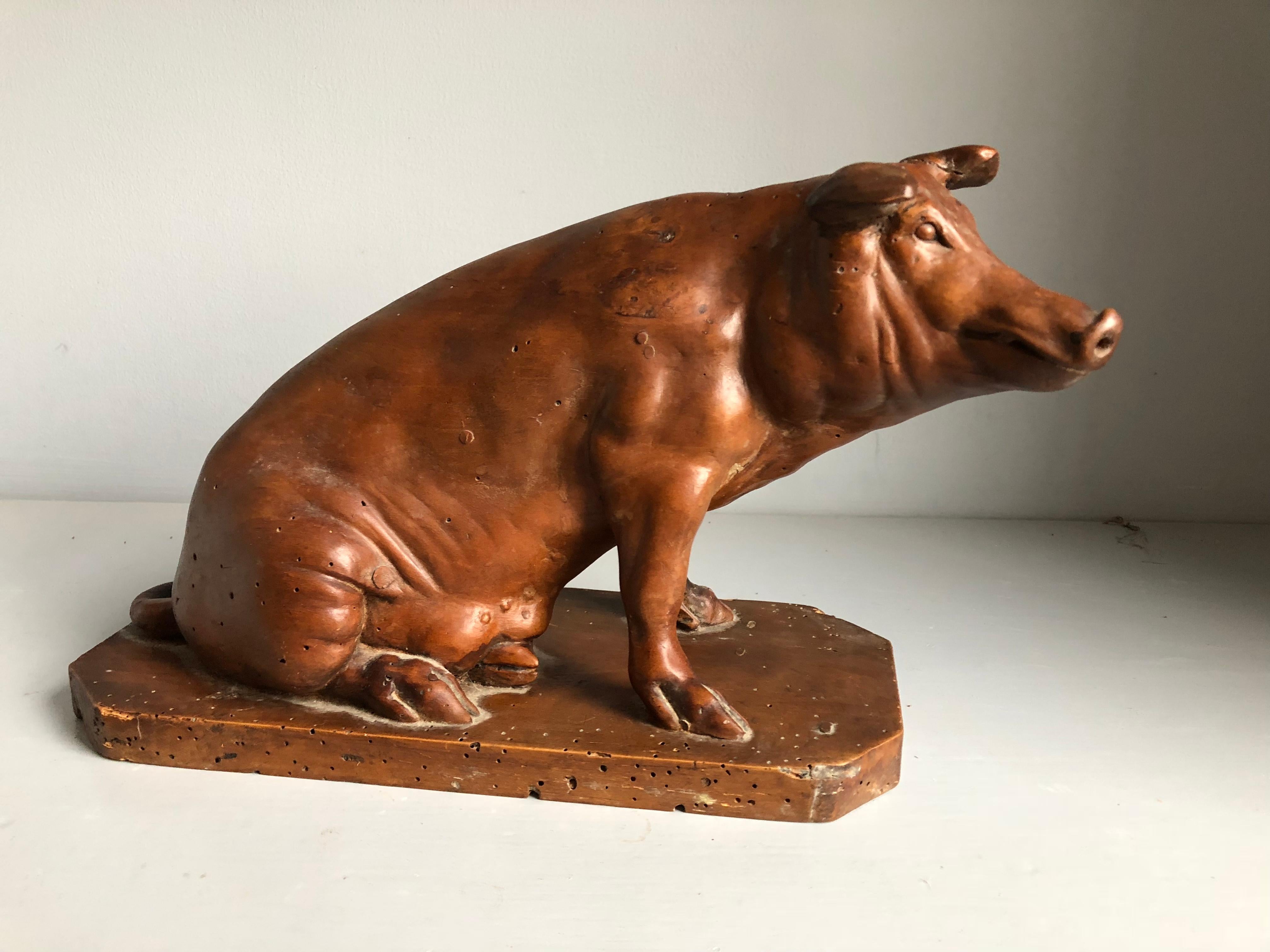 A nicely carved sculpture of a seated pig, French, early 19th Century, in fruitwood with an old patina. From the personal collection of Pierre Moulin, founder of the Pierre Deux shops and author of the French Country series of books.