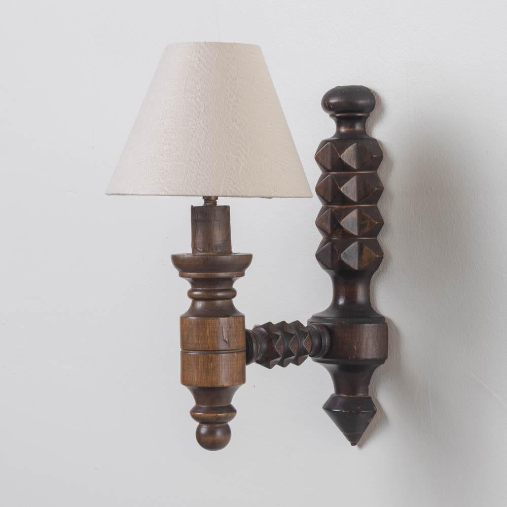 Lovely carved wood sconce by Charles Dudouyt from France, 1940s. Chevron carved stem with arm extending to hold single socket and tapered shade. Newly rewired and new linen shade. Original wood finish shows nice age and patina. Takes one E12 base