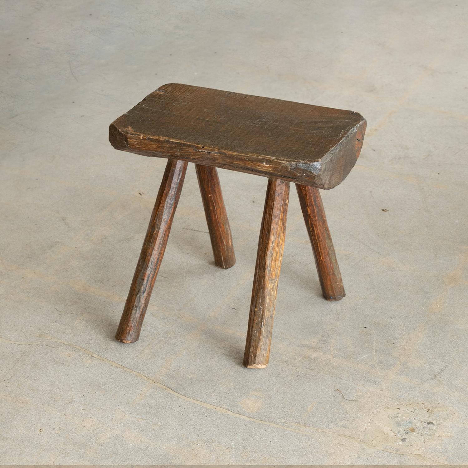 Great chunky oak wood stool from France, 1970s. Organic rectangular top, with four hand carved angled legs. Lovely grain in wood and original finish shows nice age and patina.