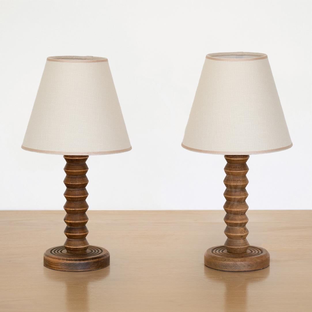 Hand carved wood table lamp from France, 1940's in the style of Charles Dudouyt. Beautiful carved design with original wood finish. New linen shade with tan trim and newly re-wired. Two available, sold individually. 

