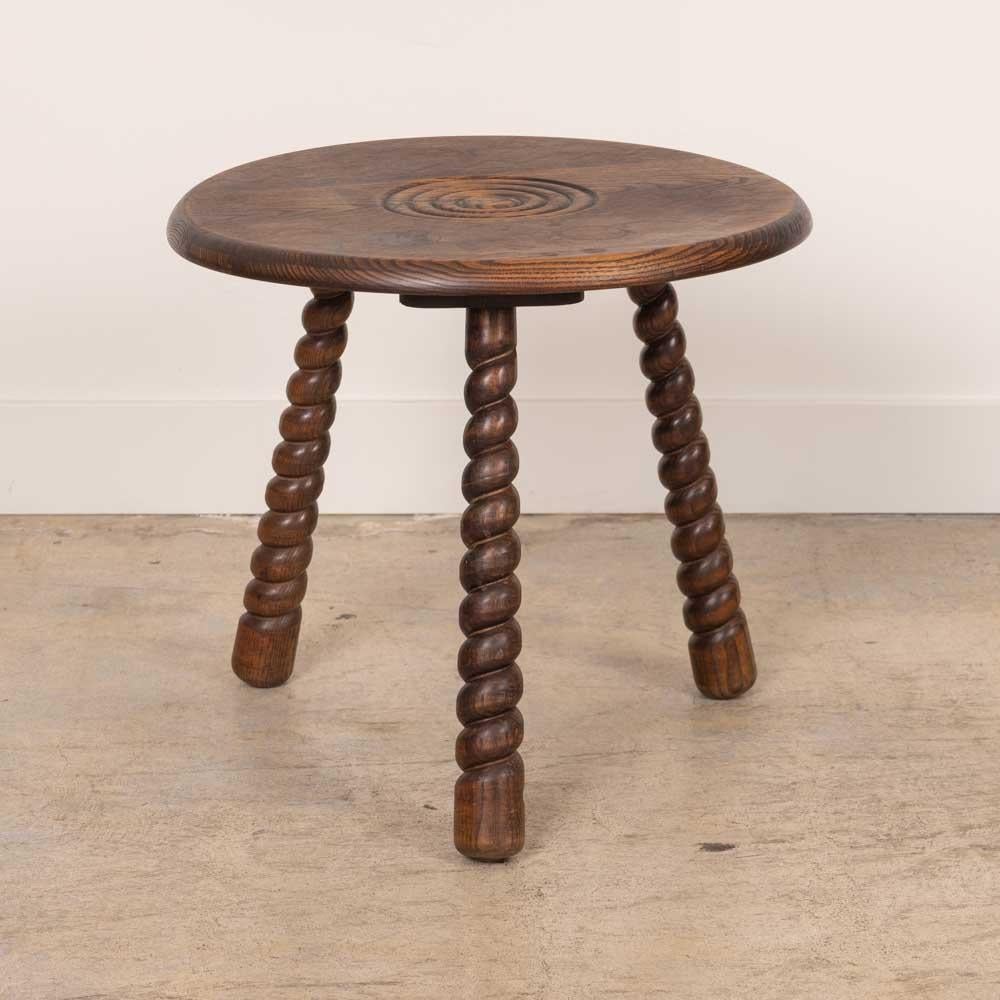 Bellissimo tavolino vintage con piano circolare e gambe a treppiede intrecciate proveniente dalla Francia, anni '50. Il piano circolare ha un bellissimo dettaglio ad anello intagliato sulla parte superiore. Finitura originale in legno con bei segni