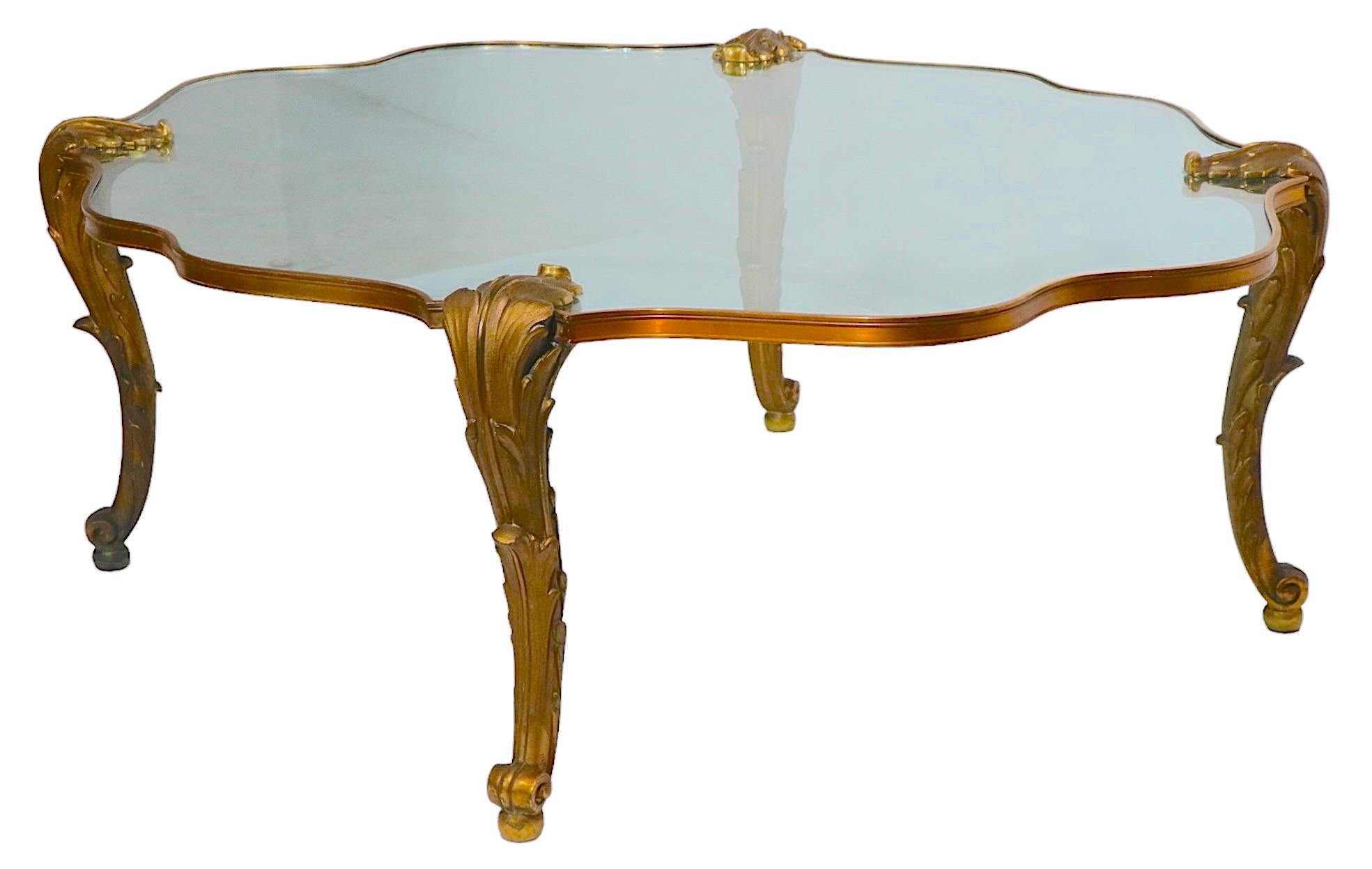 Extraordinary P.E. Guerin brass and glass coffee table having ornate cast brass legs and unusual brass trim. Made in France mid 20th C, this piece exhibits the expected quality of this top end luxury brand. The table is in excellent original