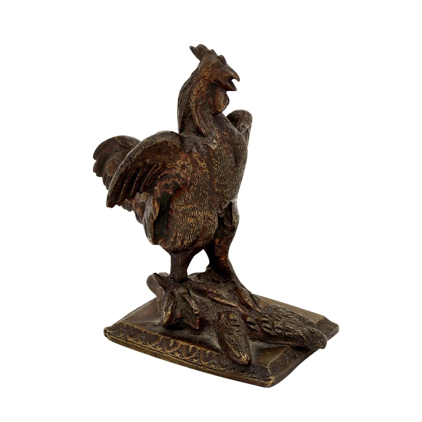 A French bronze sculpture from the 19th century depicting a rooster standing on a textured ground, his wings extended. Created during the 19th century, this bronze sculpture depicts the French national emblem, the rooster. The proud animal is