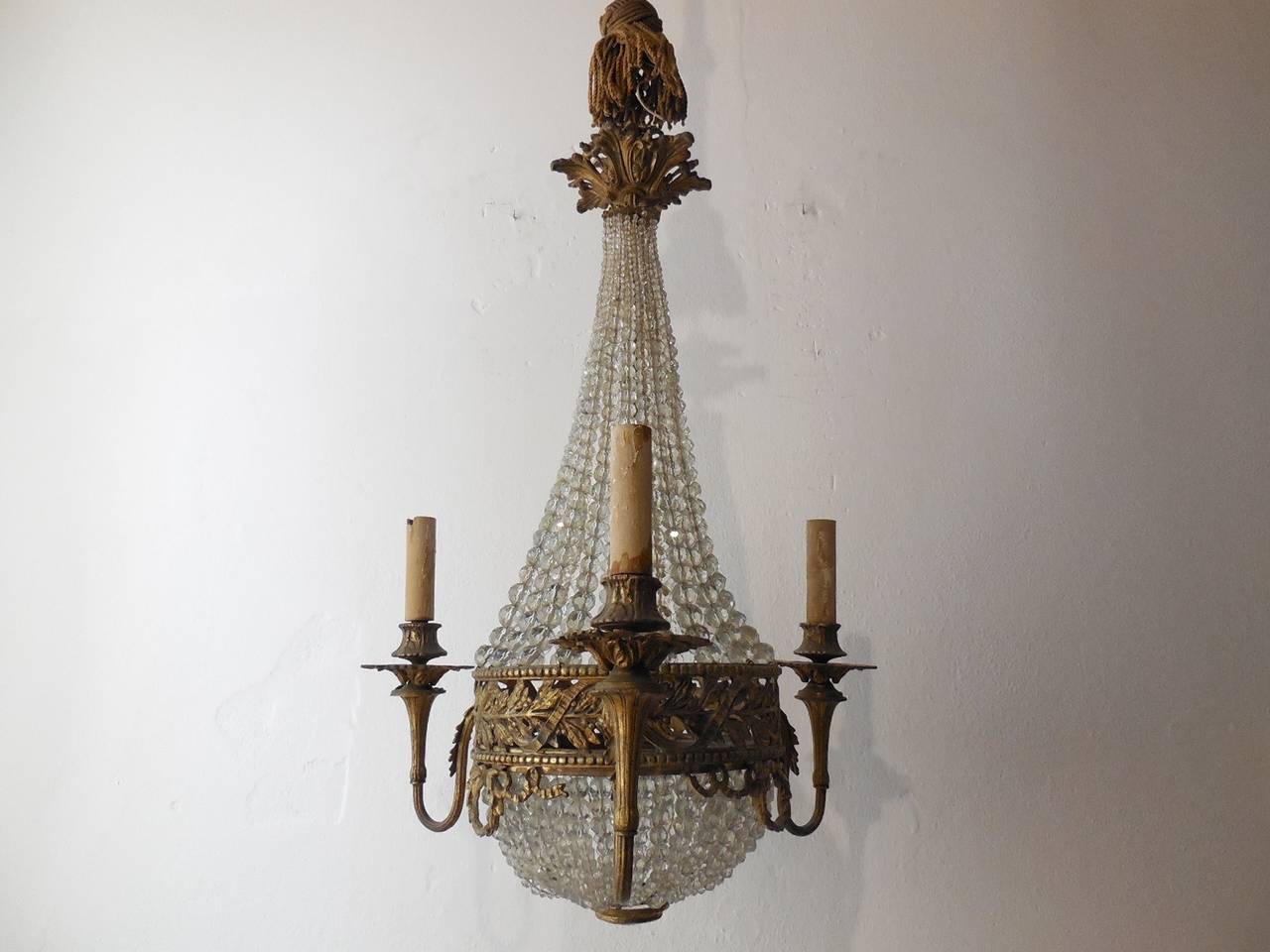 Housing 4 lights, 3 outside and one in center. Heavy detailed bronze with perfect patina. Rows and rows of crystal beads, all hand cut, going from big to small. Huge prism on bottom as finial. Adding an additional 24 inches of the original stiff