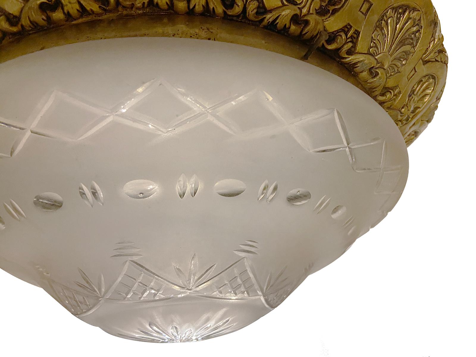 A French circa 1920's cast bronze flush-mounted light fixture with a frosted and cut crystal globe and a shell pattern on the body.

Measurements:
Height 8