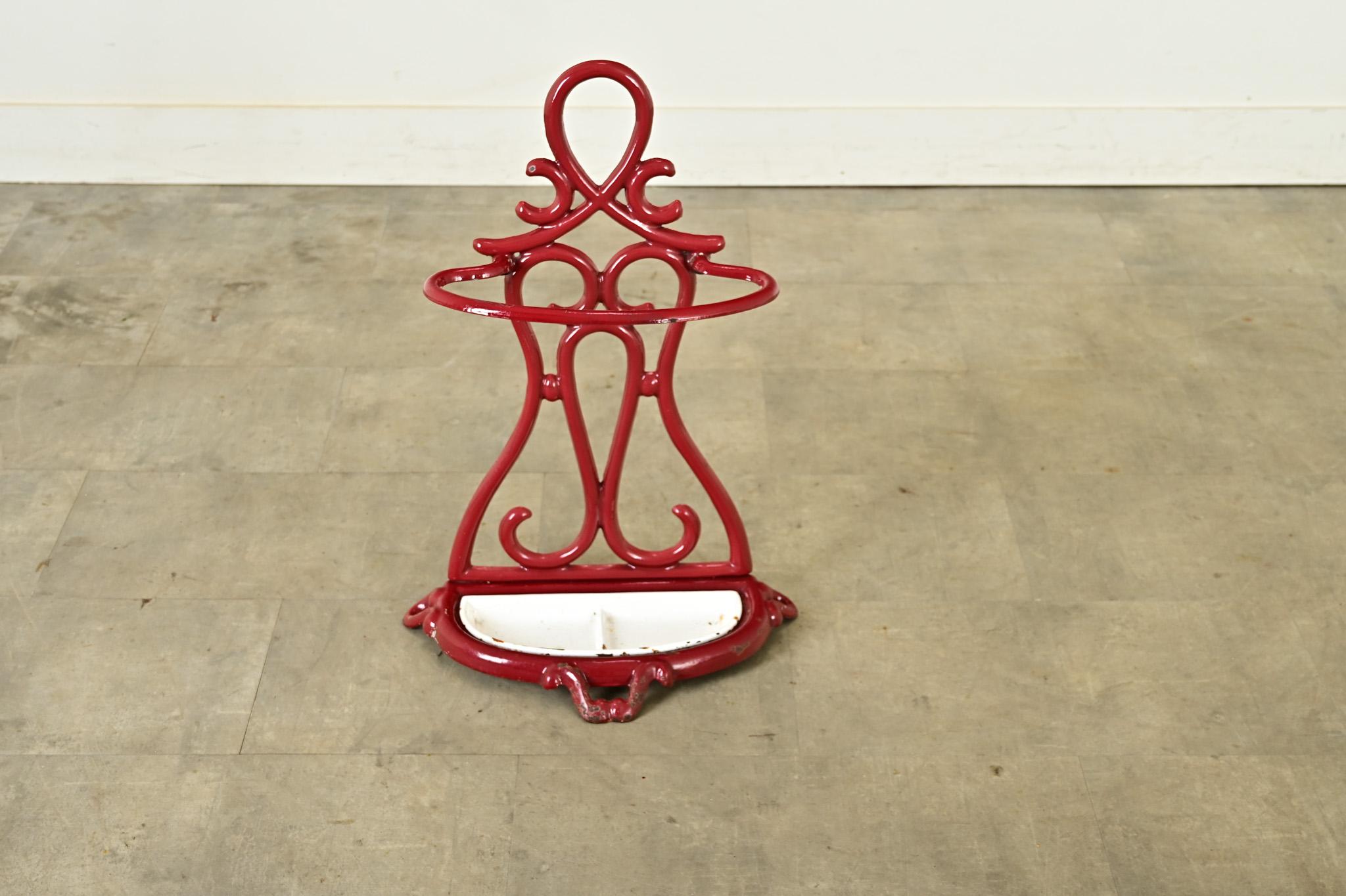 A calligraphic French Art Nouveau umbrella stand, made of cast iron enameled in a glossy oxblood red. Expressive loops and curls of the metal frame scroll with the fantastic exuberance of Rococo or Chinoiserie to become a gorgeous statement by any