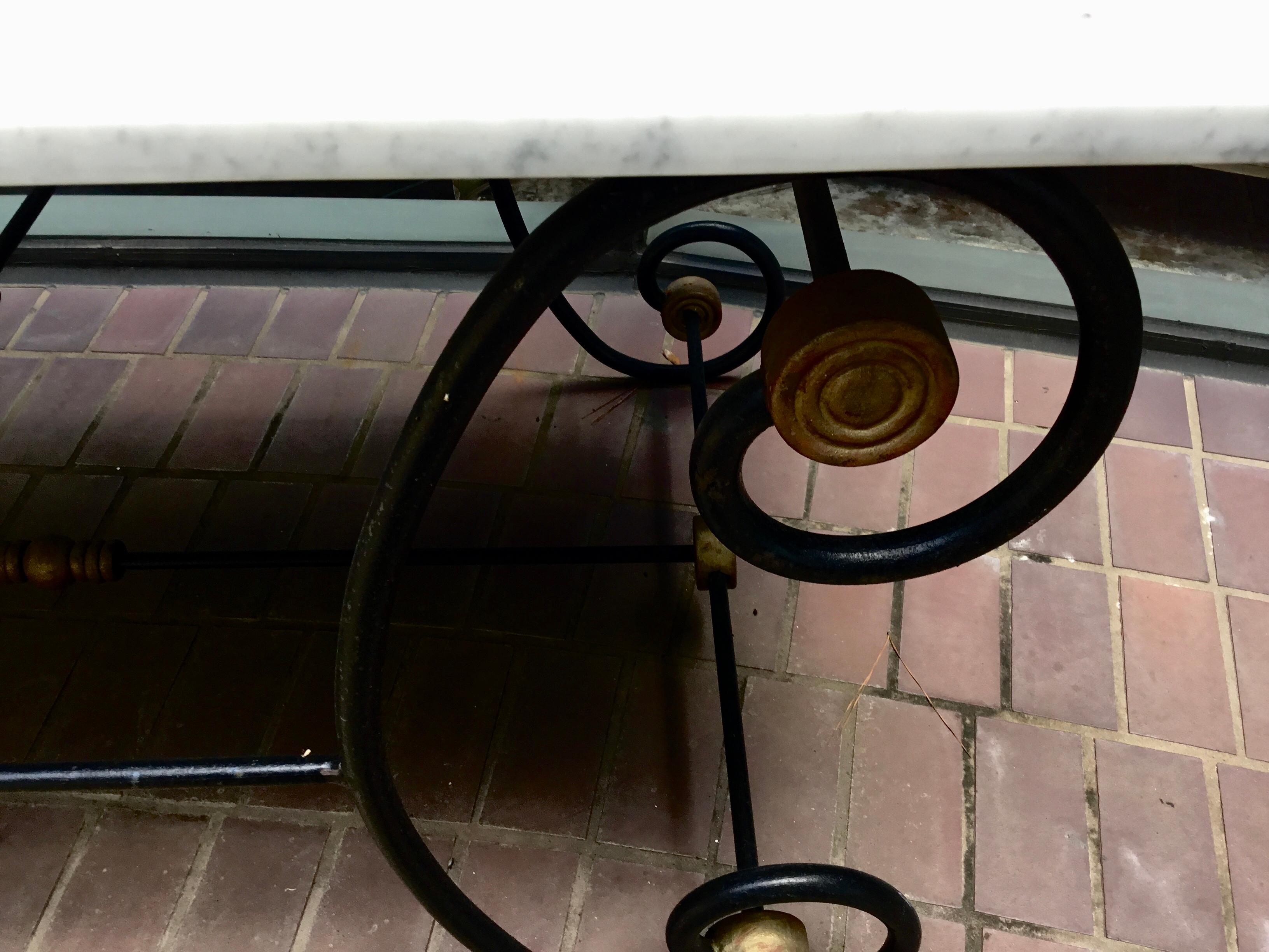 French bakers table with white marble top. Great for kitchen use or on the patio for serving.
White marble top has light gray veins. The iron work has beautiful scrolling legs and design work
With gilt joints.