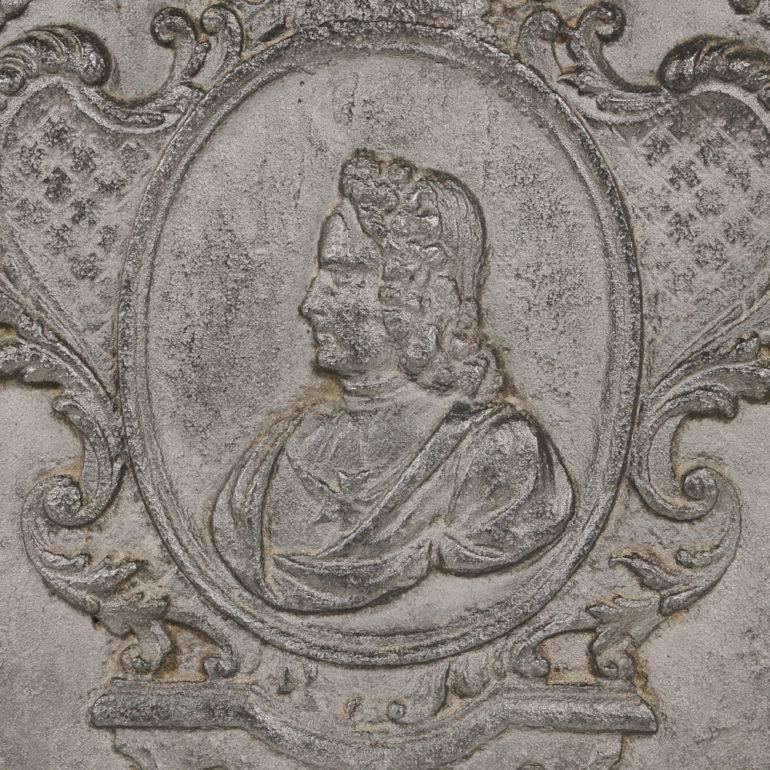 A French cast iron, Baroque style, fireplace plaque, the central ‘cartouche’ with a portrait surmounted by a crown, circa 1800.



              