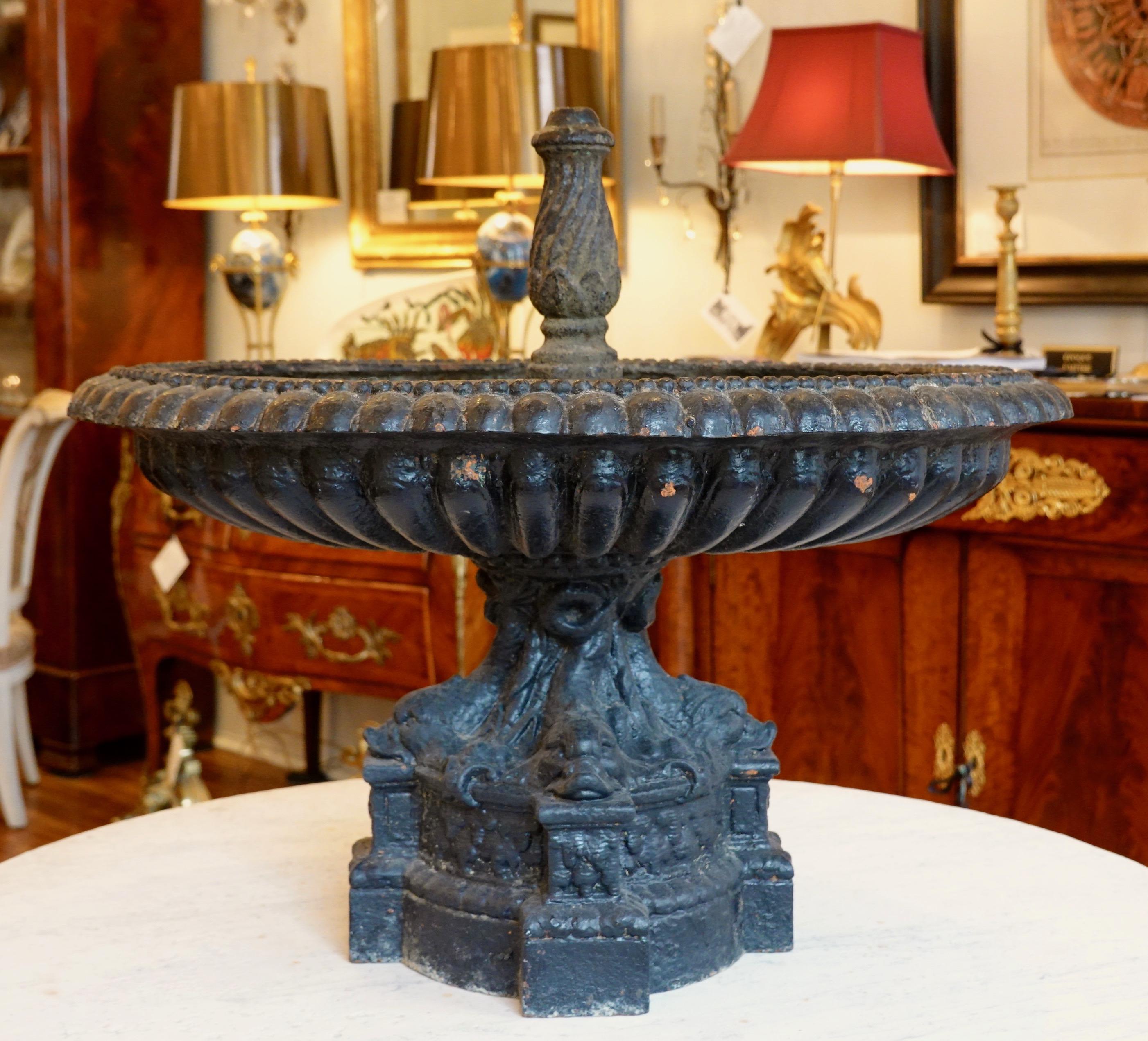A rare and highly-decorative French cast iron fountain by the Val d'Osne Foundry. The oval tazza form bowl is lobed with pearl beads around the inner perimeter, and is supported on a base of four mythical dolphins. The fountain is depicted in the