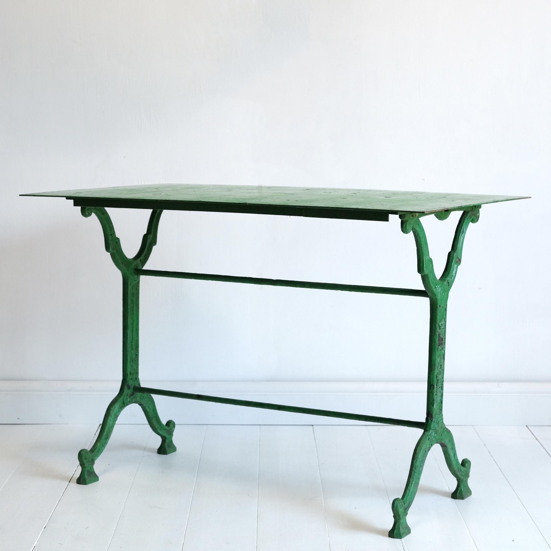 A very good quality French 19th century cast iron garden table by Groeff of Toulon. Layers of old paint with the most prominent being a striking but very tasteful green. Two very well-cast decorative trestle type supports united by twin rod