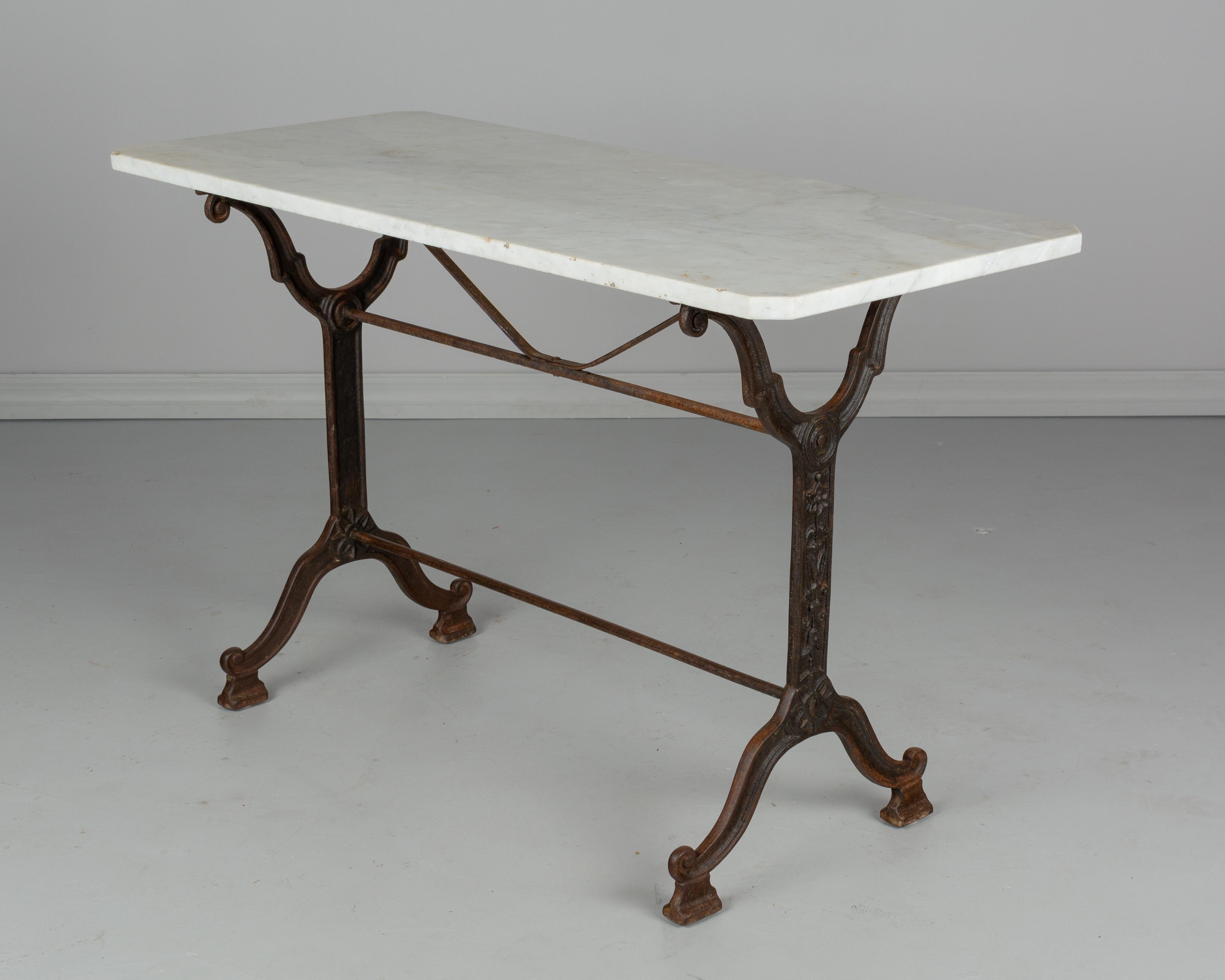 A French cast iron bistro table with marble top. Nice casting with stylized floral motif and warm patina. White marble top is 3/4