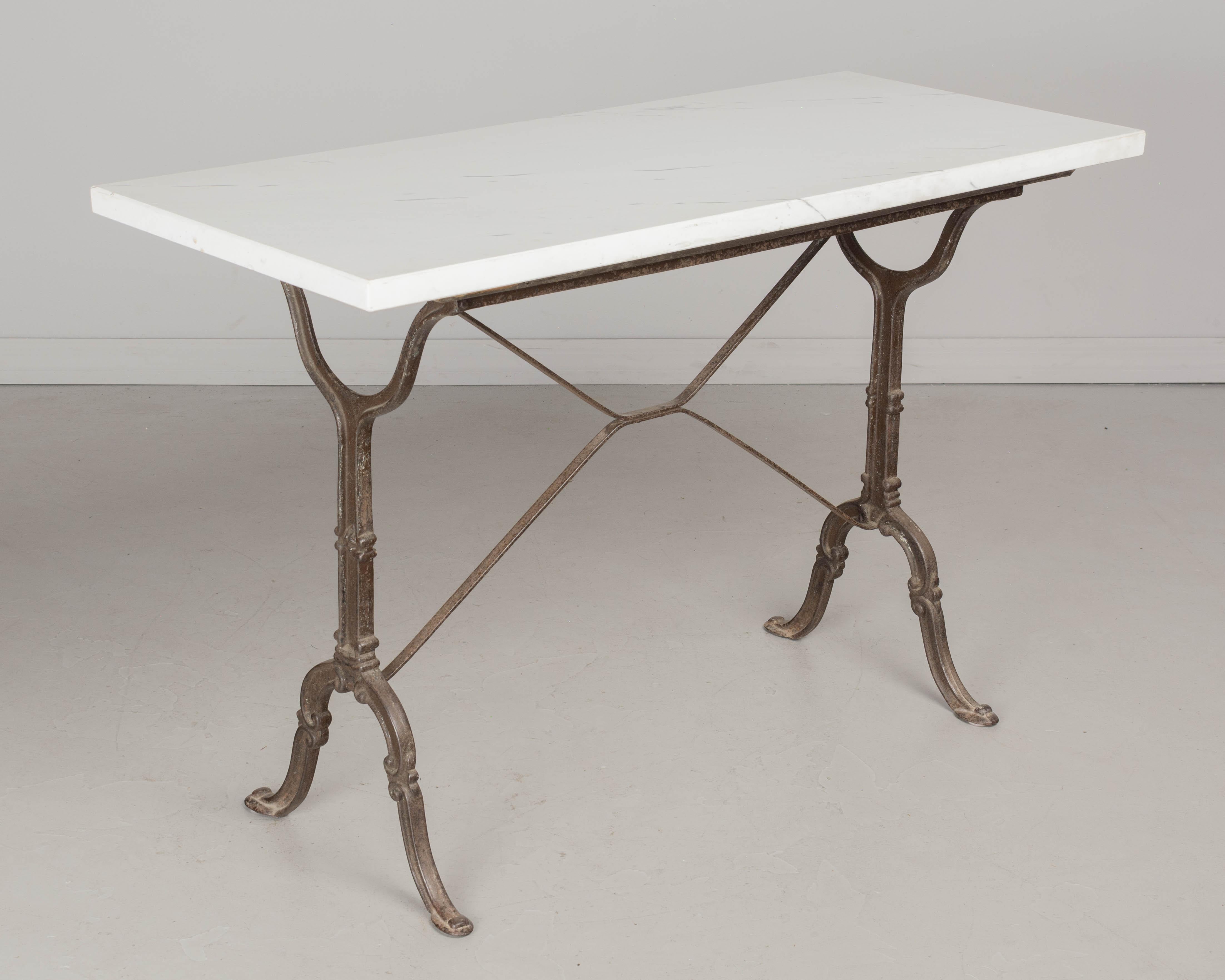 A French cast iron bistro table with newer polished white veined marble top. Perfect for outdoor use. Circa 1900-1910 (marble c. 1980's)
Dimensions: 45.25