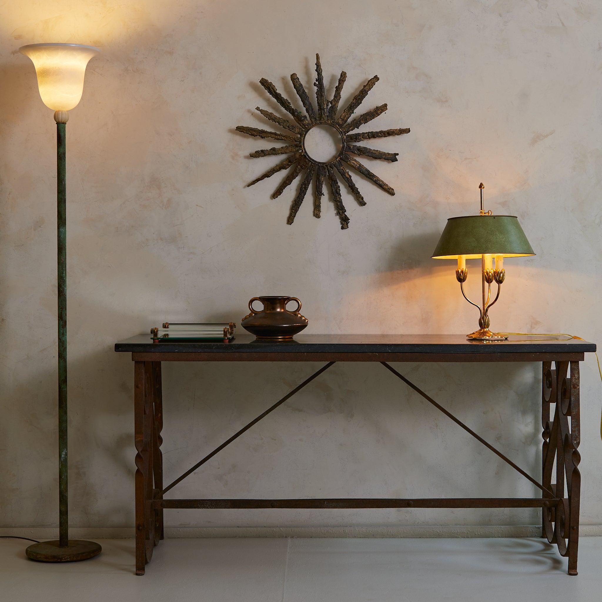 A quiet relic of 1940s France, this console table bridges the industrial and the ornate. Its cast iron frame, rich with scrollwork, carries the weight of time—with a rich patina that stands as a testament to decades past. The honed charcoal-hued