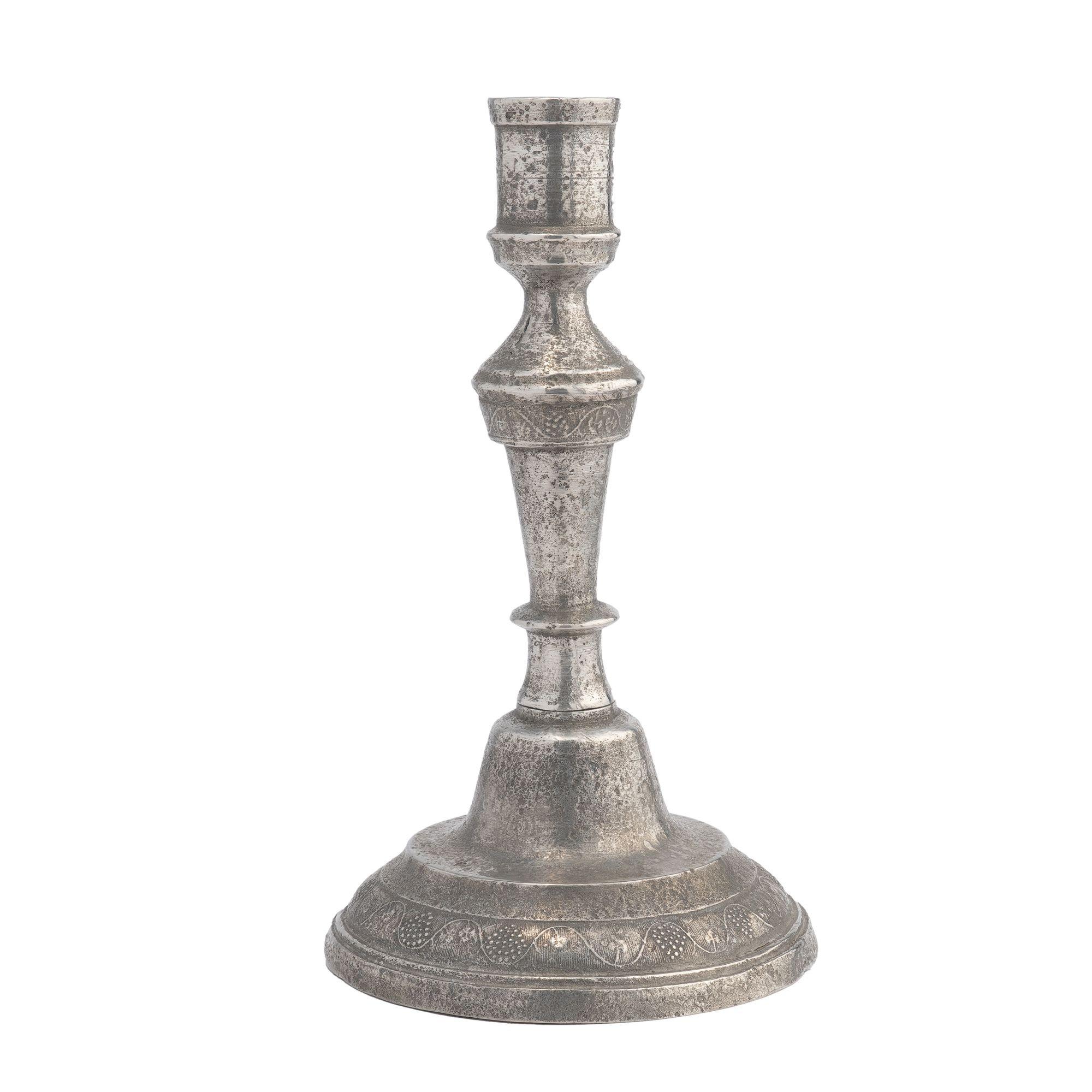 Kontinentaler Zinnguss-Kerzenhalter mit zartem Weinrebenmotiv um den kreisförmigen gewölbten Sockel und auf dem zylindrischen Kragen zwischen dem Kerzenbecher und dem sich verjüngenden Schaft.

Frankreich, um 1770.