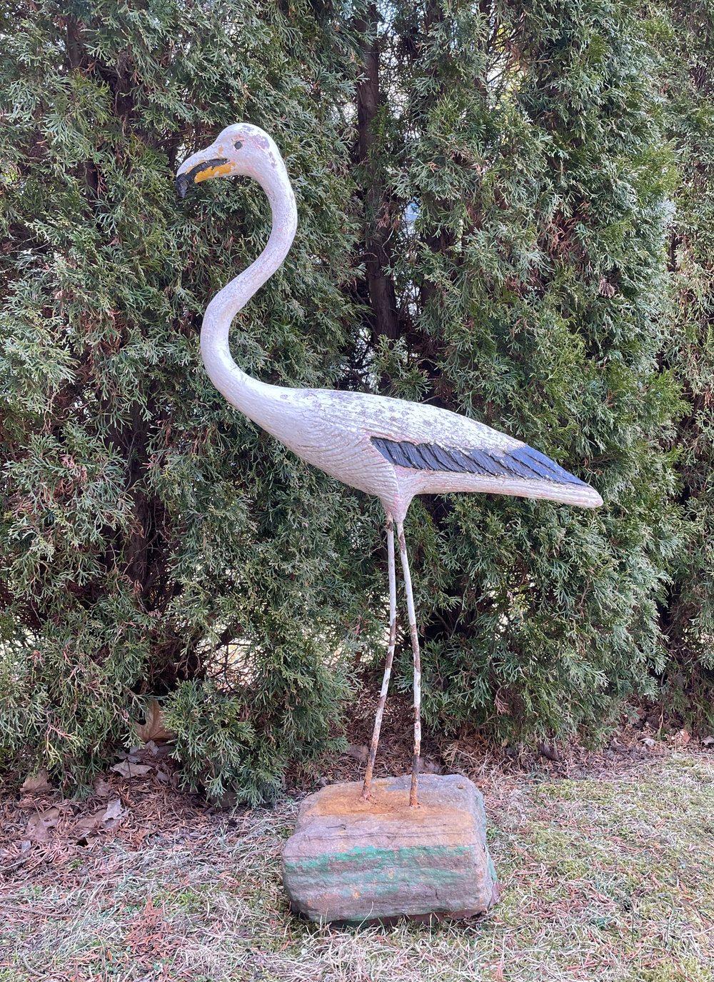 We jumped at the chance to buy a grouping of three early French flamingos, and this is the white flamingo with a black and yellow-trimmed beak and wings. Made of cast stone with iron legs and mounted in a carved stone base, he is very solid and cuts