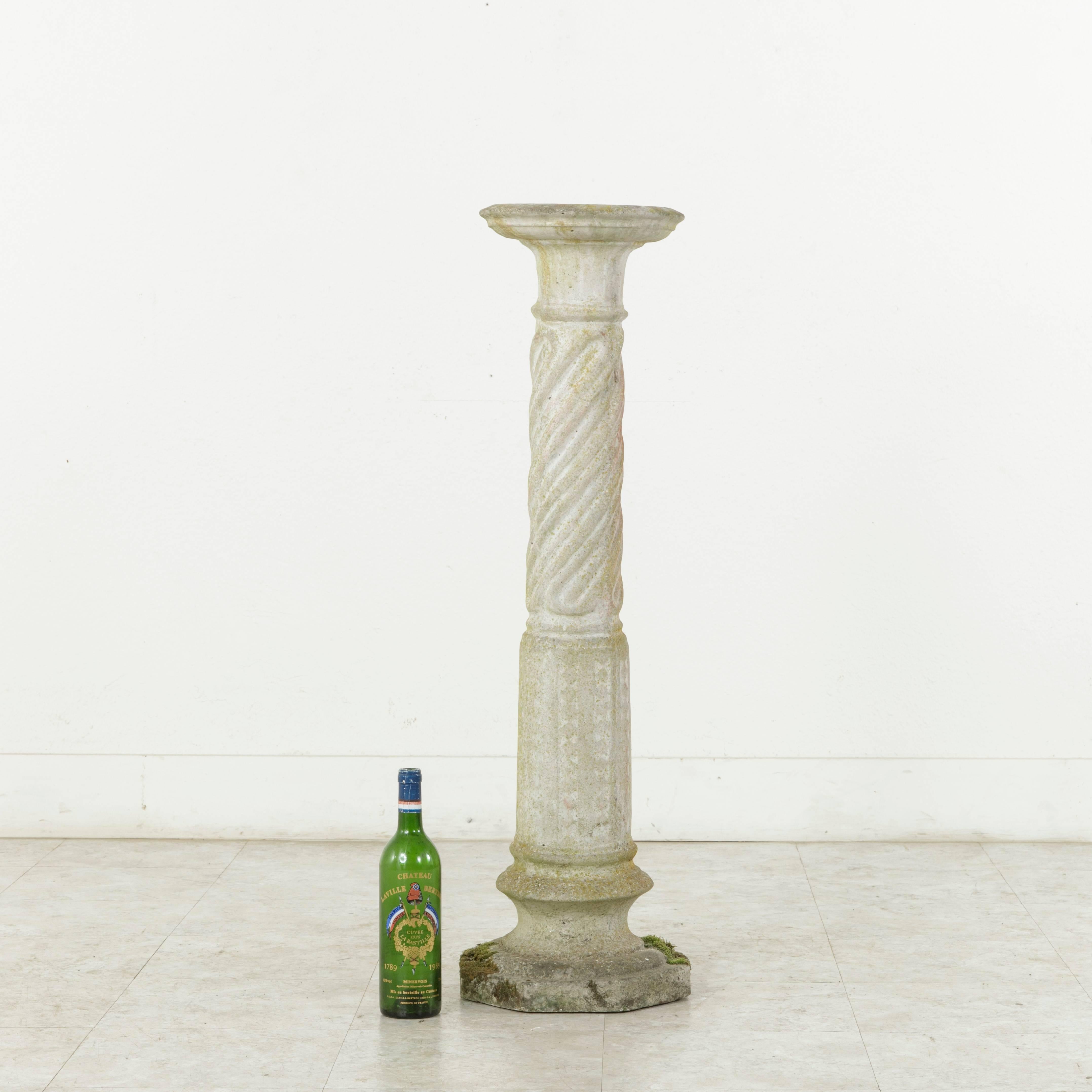 Originally from the gardens of a manor house in Normandy, France, this early 20th century cast stone column stands at 39 inches in height and features spiral fluting on the upper half and a diamond pattern on the lower half. Its beautifully aged