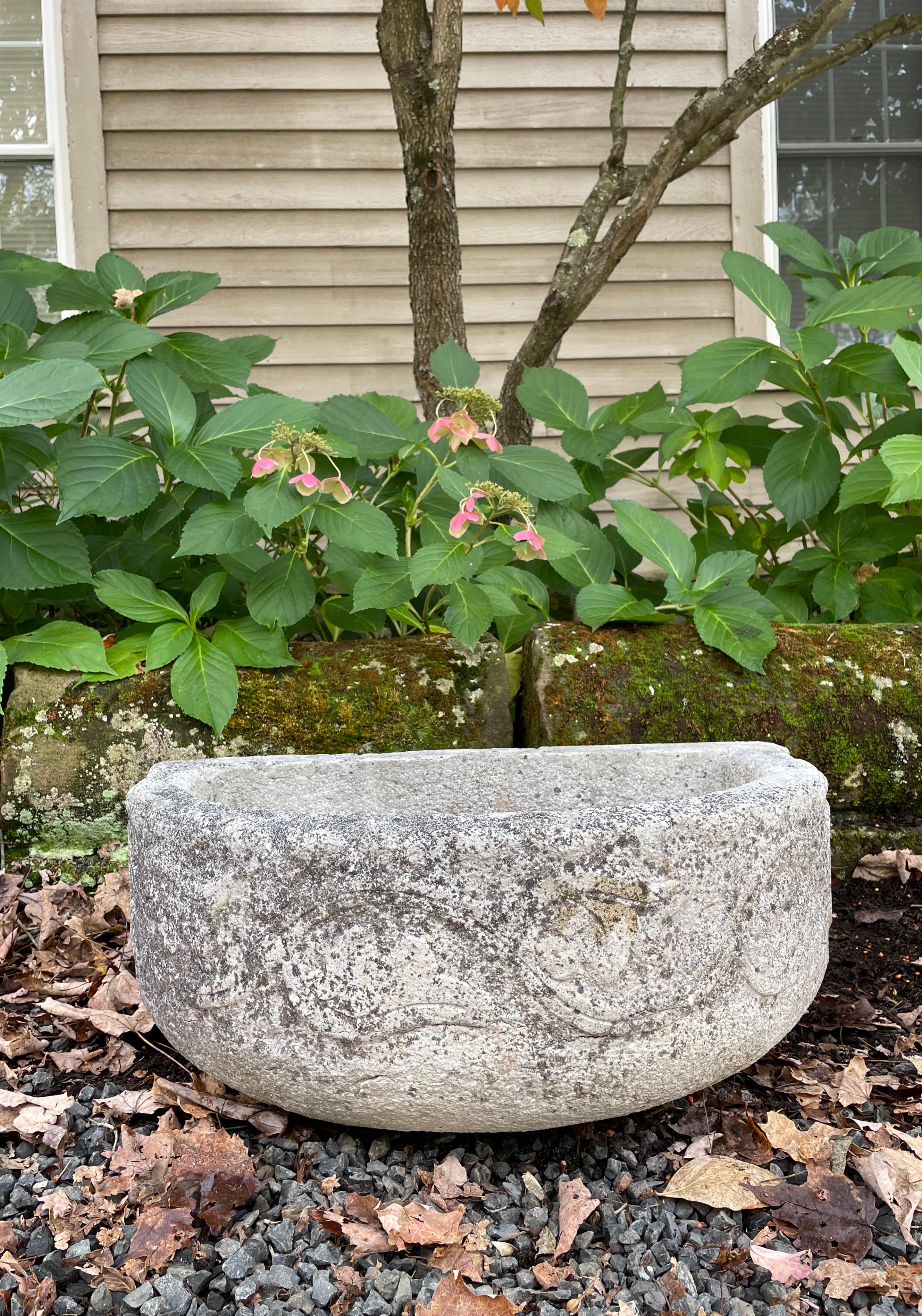 Antique stone basins are always in demand and this one is a beauty! Featuring incised scrolls on the front radius that makes it appear older than it is, this basin has a beautifully-weathered patina and its size and form will lend an ancient note to
