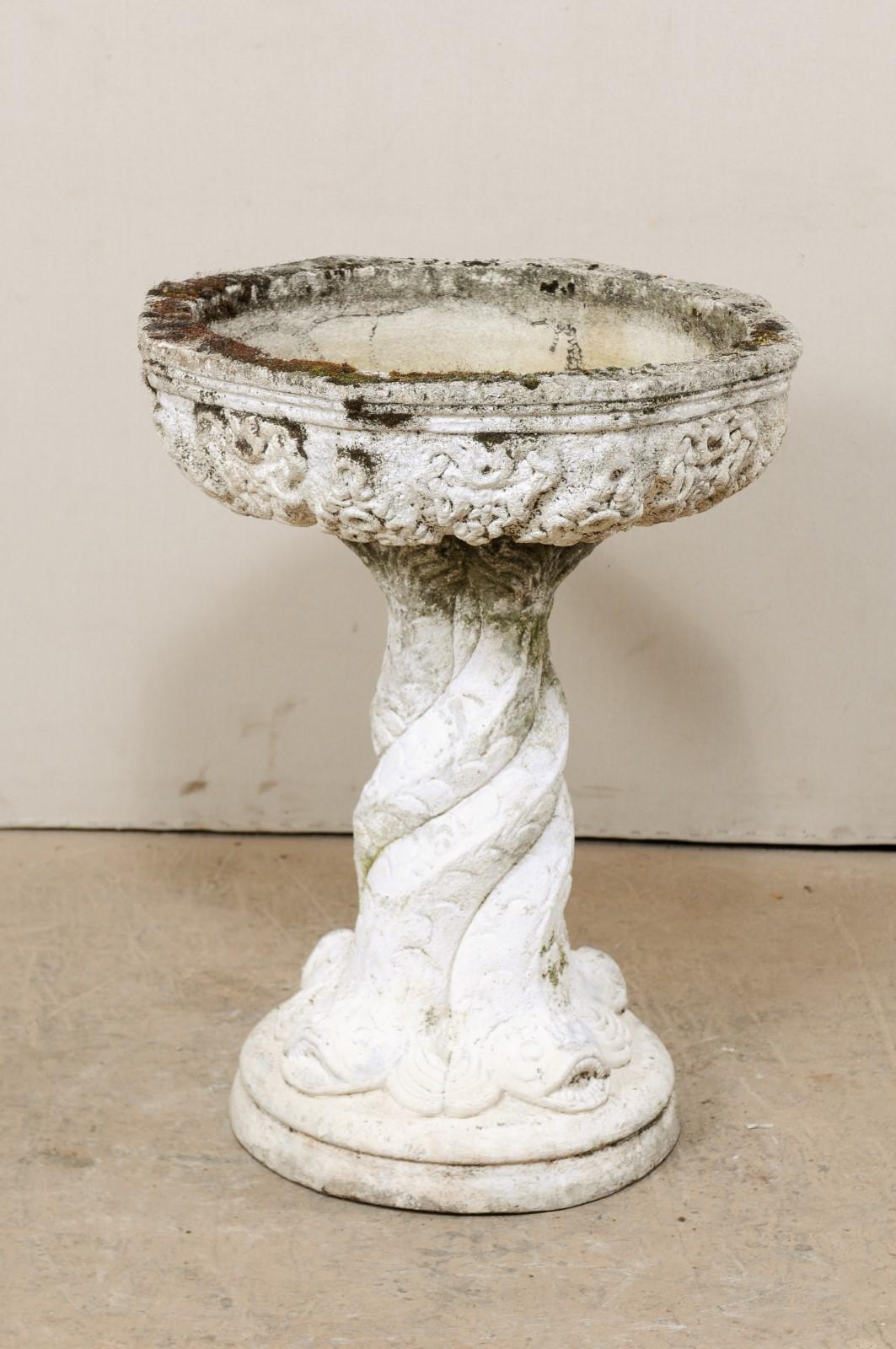 A French garden pedestal planter or fountain basin. This vintage cast-stone planter from France features a rounded vessel, just over 2 feet in diameter, which is raised nicely upon a central column adorn in mythological sea creatures wrapping about
