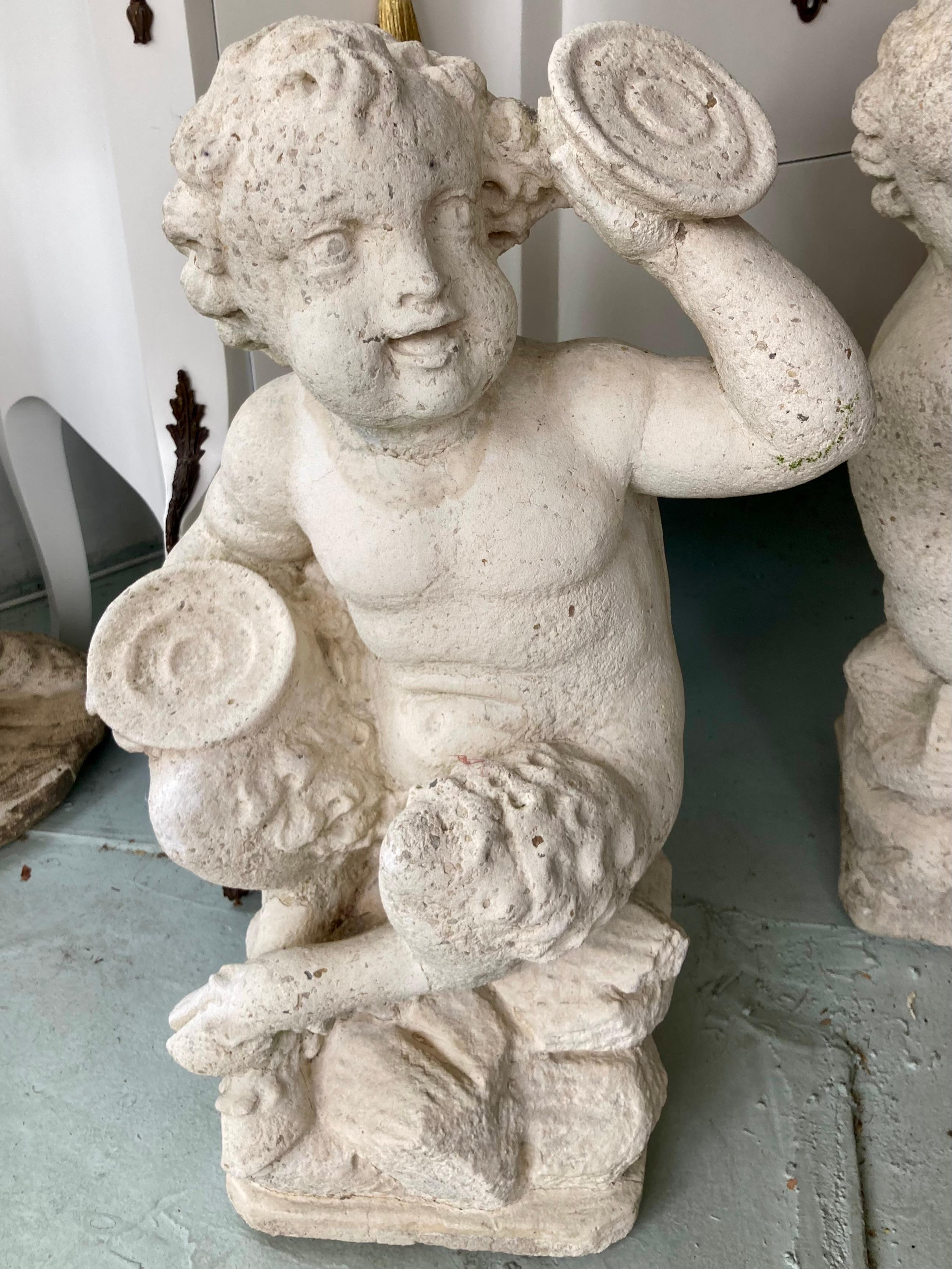 Beautiful pair of French cast stone Pan and Putti musician sculptures. We have two pairs available in stock.