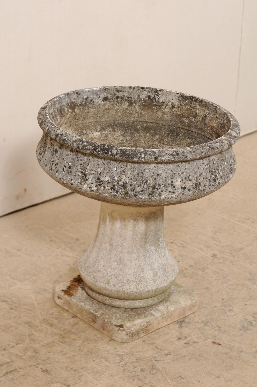 A French garden pedestal planter from the mid-20th century. This vintage cast-stone planter from France features a rounded vessel (approximately 8.75