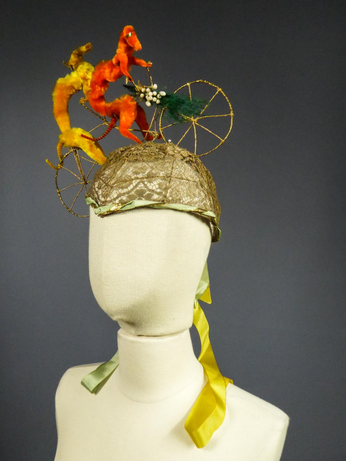 Circa 1920/1930
France

Moving bell-shaped Catherinette headdress surmounted by an astonishing tandem bicycle of plush greyhounds, probably from a Parisian fashion designer house between the two 20th century Worldwars. Elaborate work of a