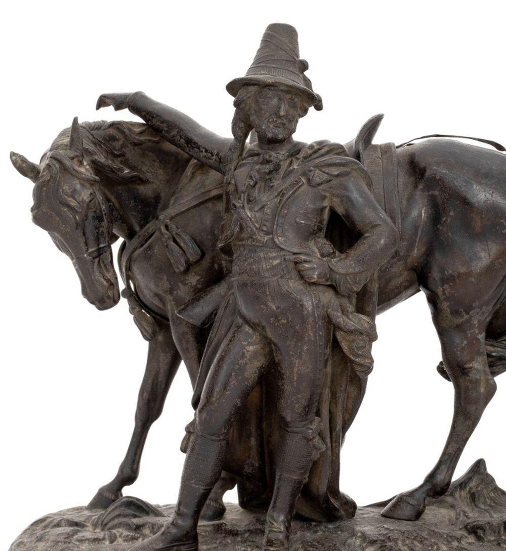 Sculpture française en métal patiné représentant un cavalier et sa monture, fin du XIXe siècle, la figure se tenant sur une base ovale naturaliste, apparemment non signée. 10.25