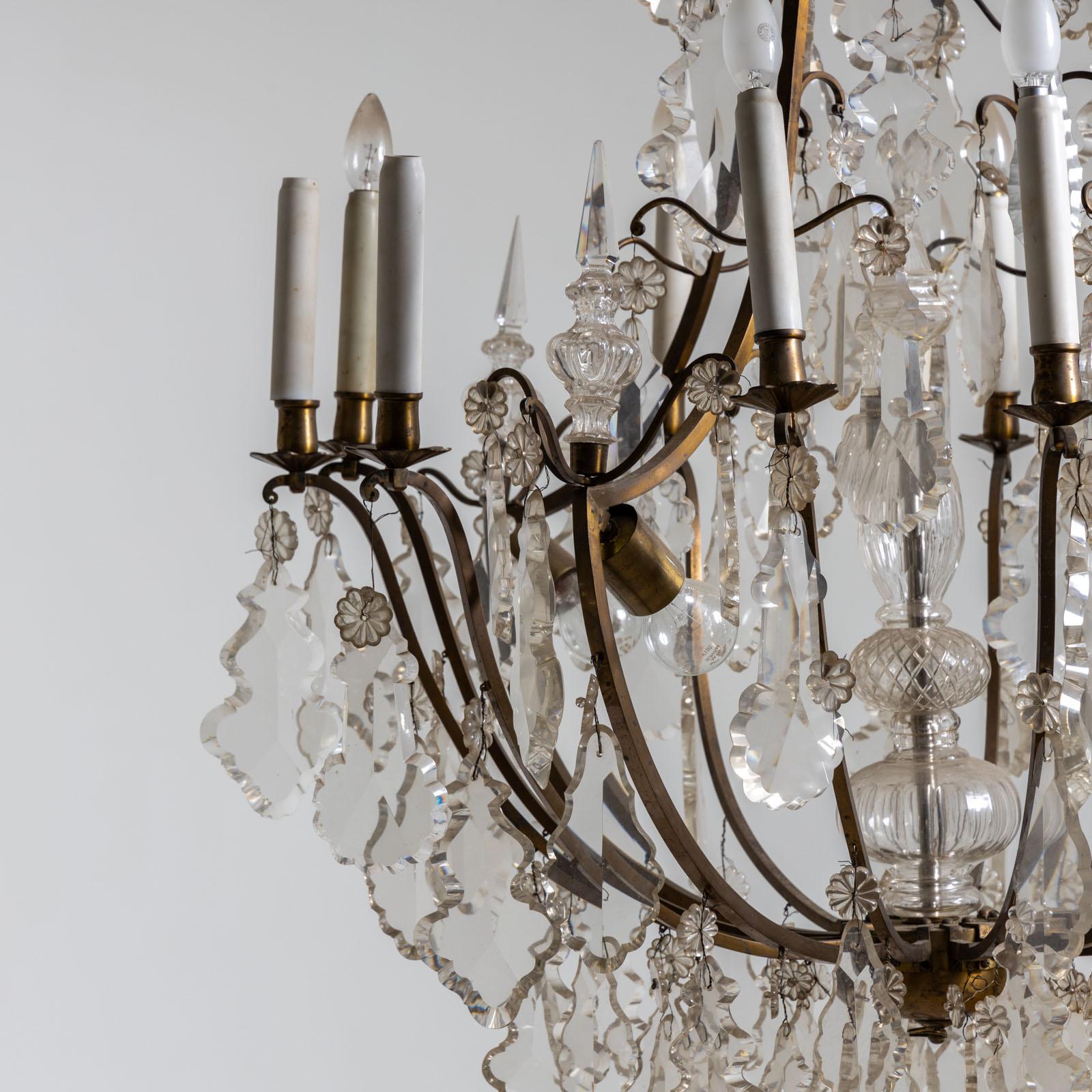Grande lampadario da soffitto con sospensione in vetro tagliato e dodici prese a forma di candela, oltre a due ulteriori prese all'interno del cesto. L'intelaiatura del lampadario a soffitto è realizzata in bronzo ed è stata elettrificata. 