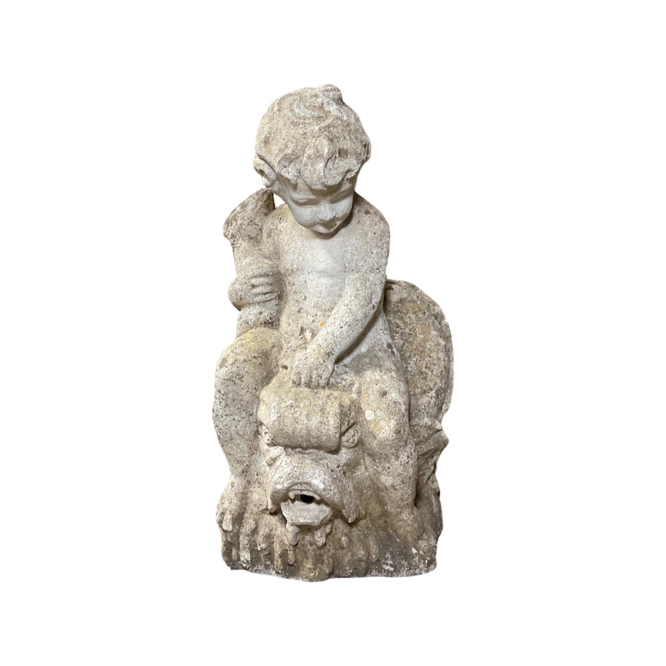 A beautiful French Limestone Cherub Fountain Head Water Exit from 1950. Hand-carved with exquisite detail, this unique piece features a cherub on a fish creature and will add an air of elegance to any outdoor space. Make a statement with this